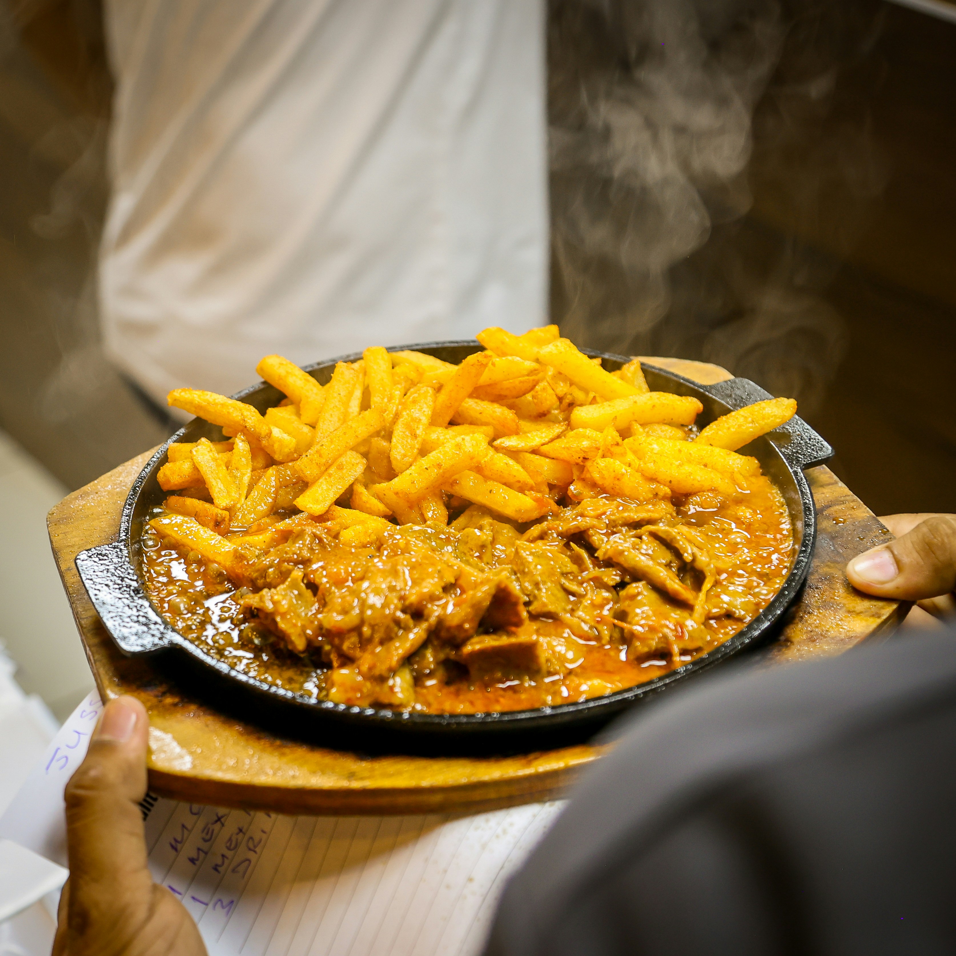 Filete chisporroteante con patatas fritas servidas en una placa caliente