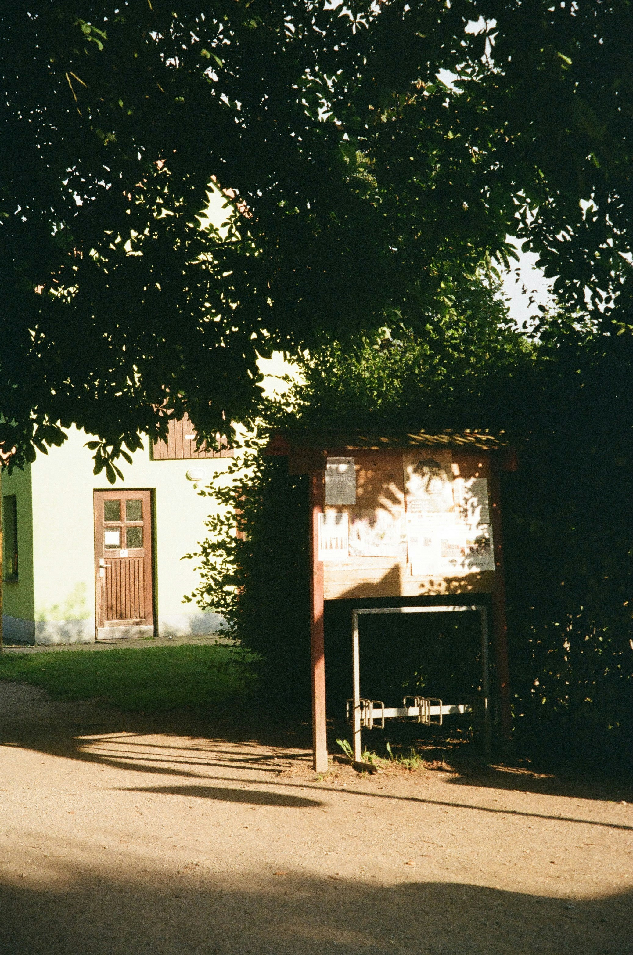Building with outdoor information board under trees