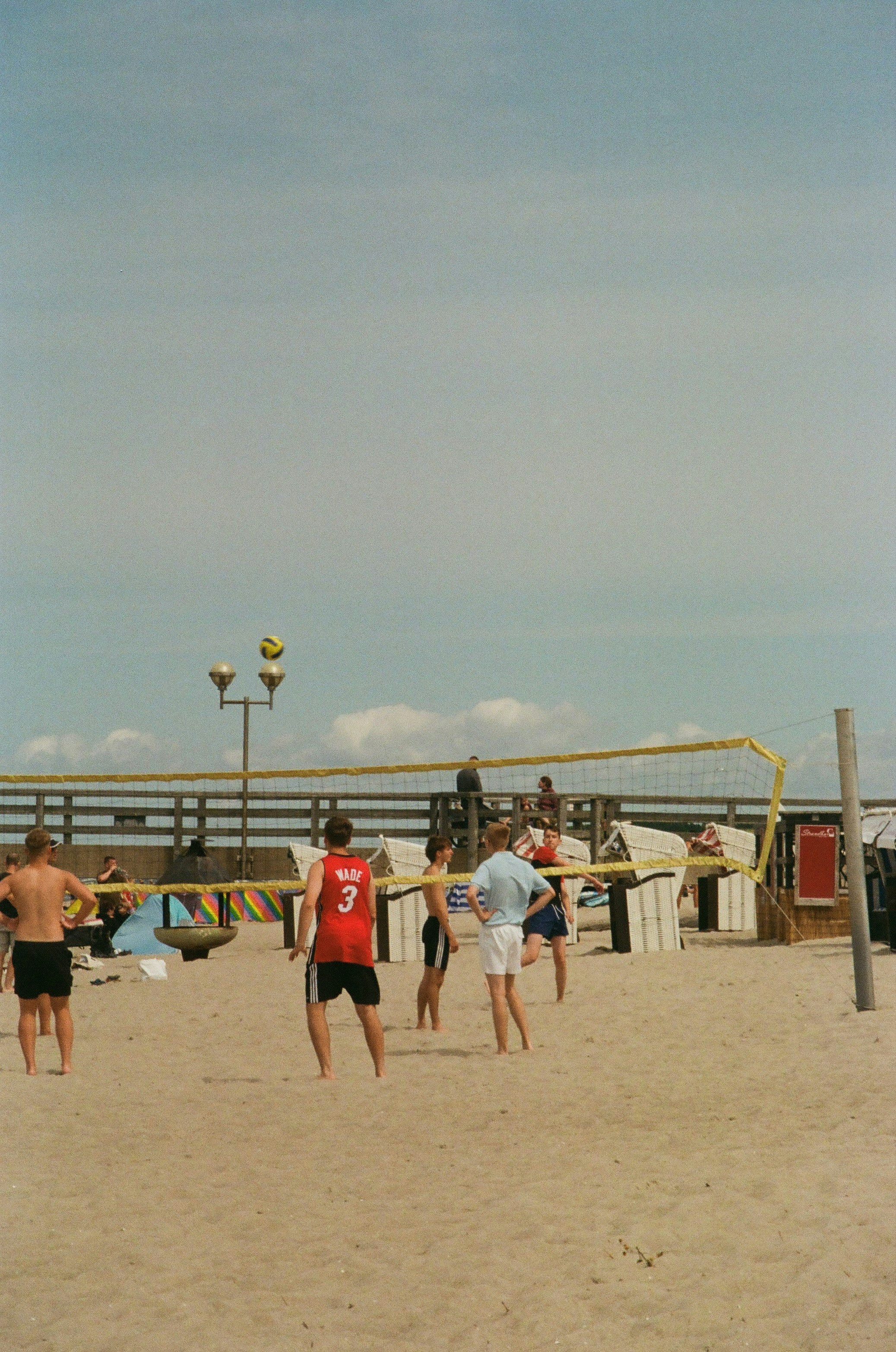 People playing volleyball on a sandy beach.