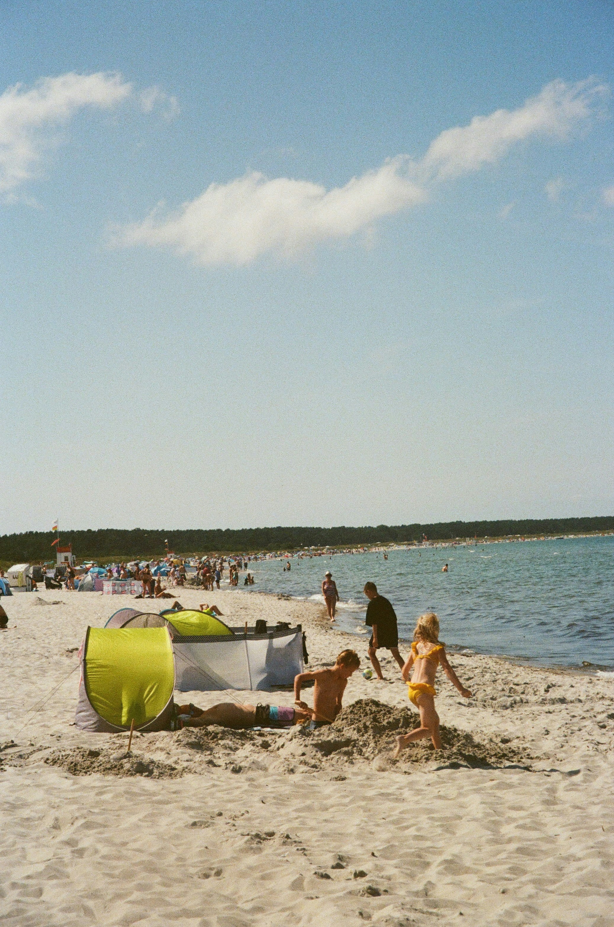 People enjoying a sunny day at the crowded beach.