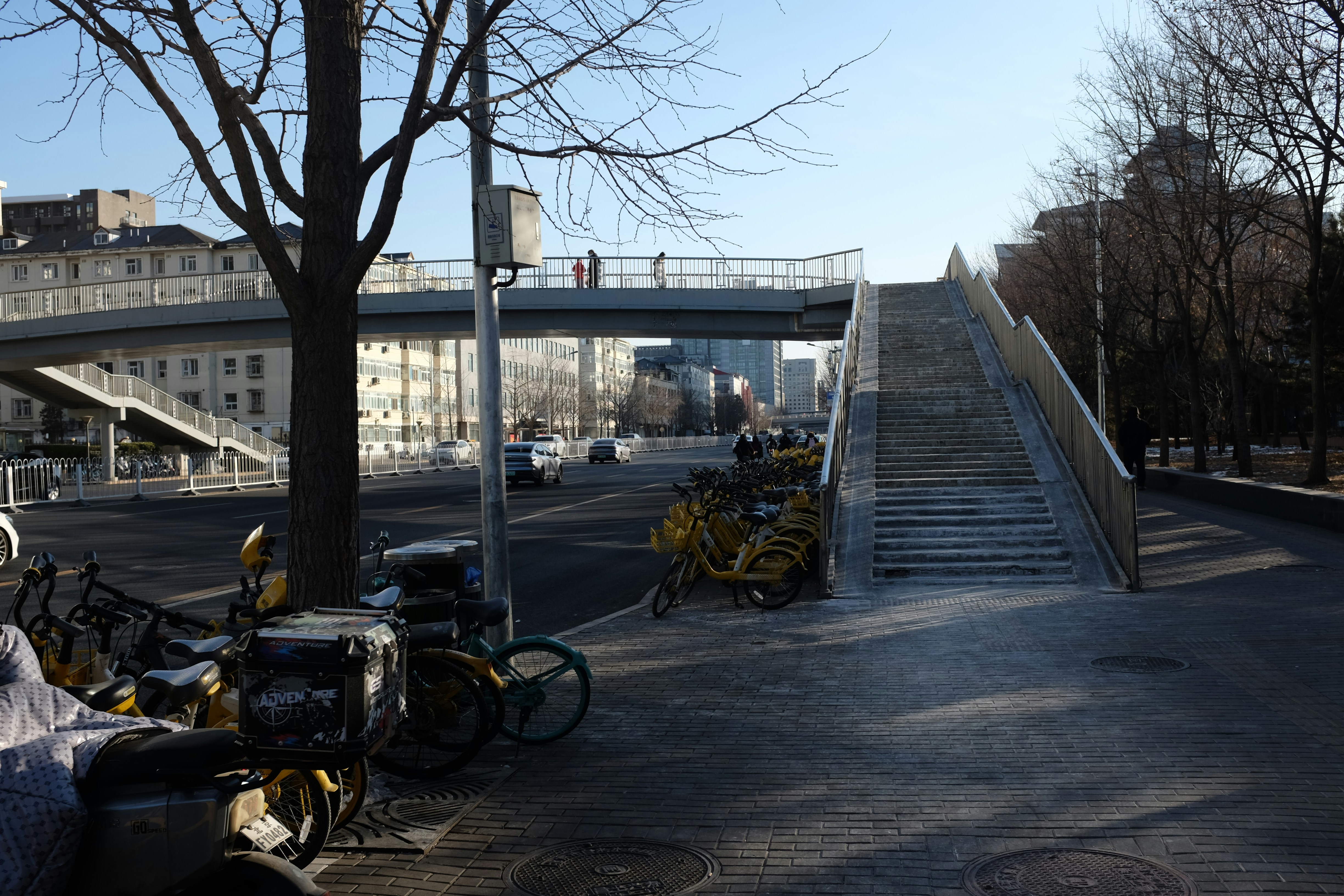Staircase leading to a pedestrian overpass with bicycles nearby.