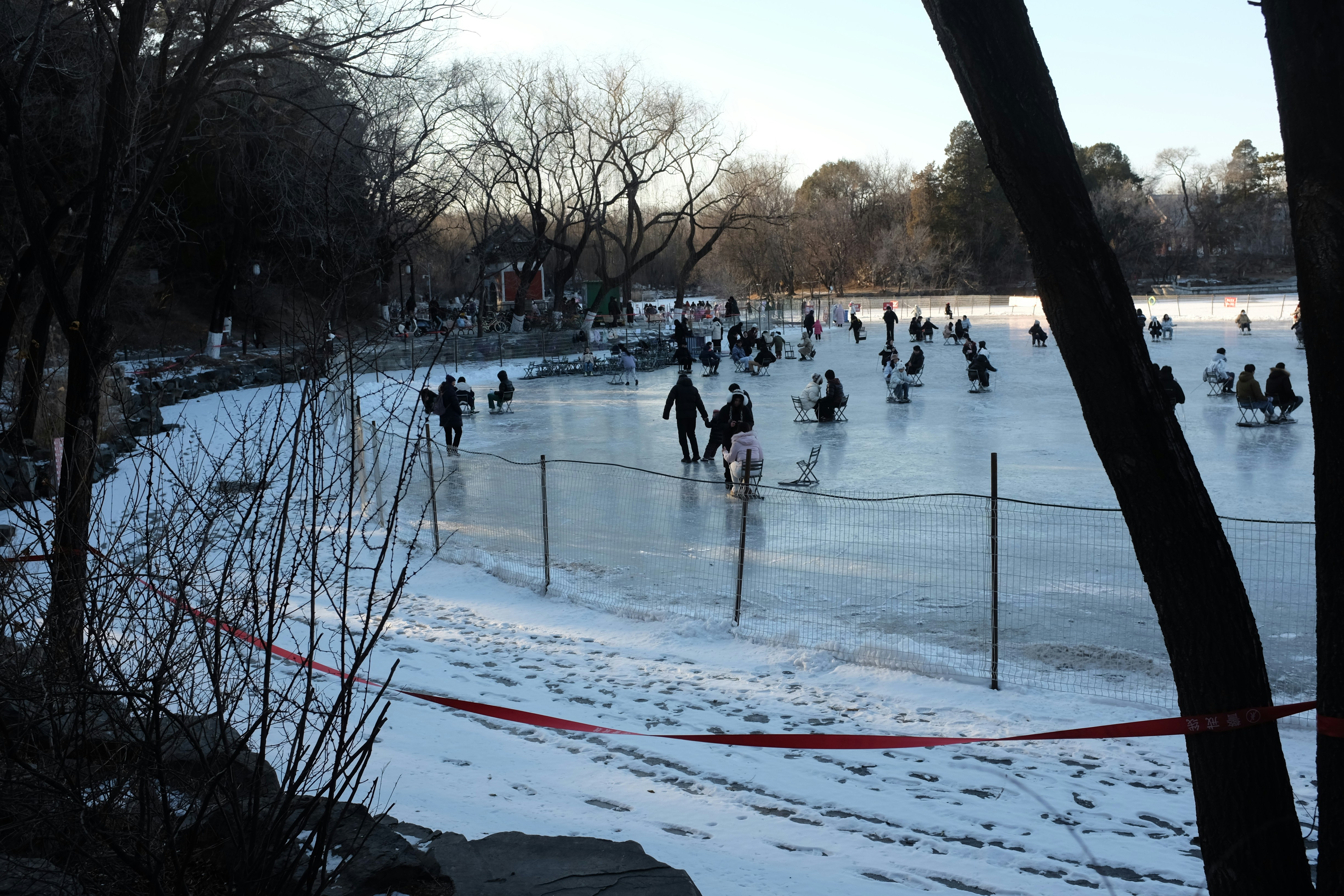 People ice skating on a frozen lake in winter