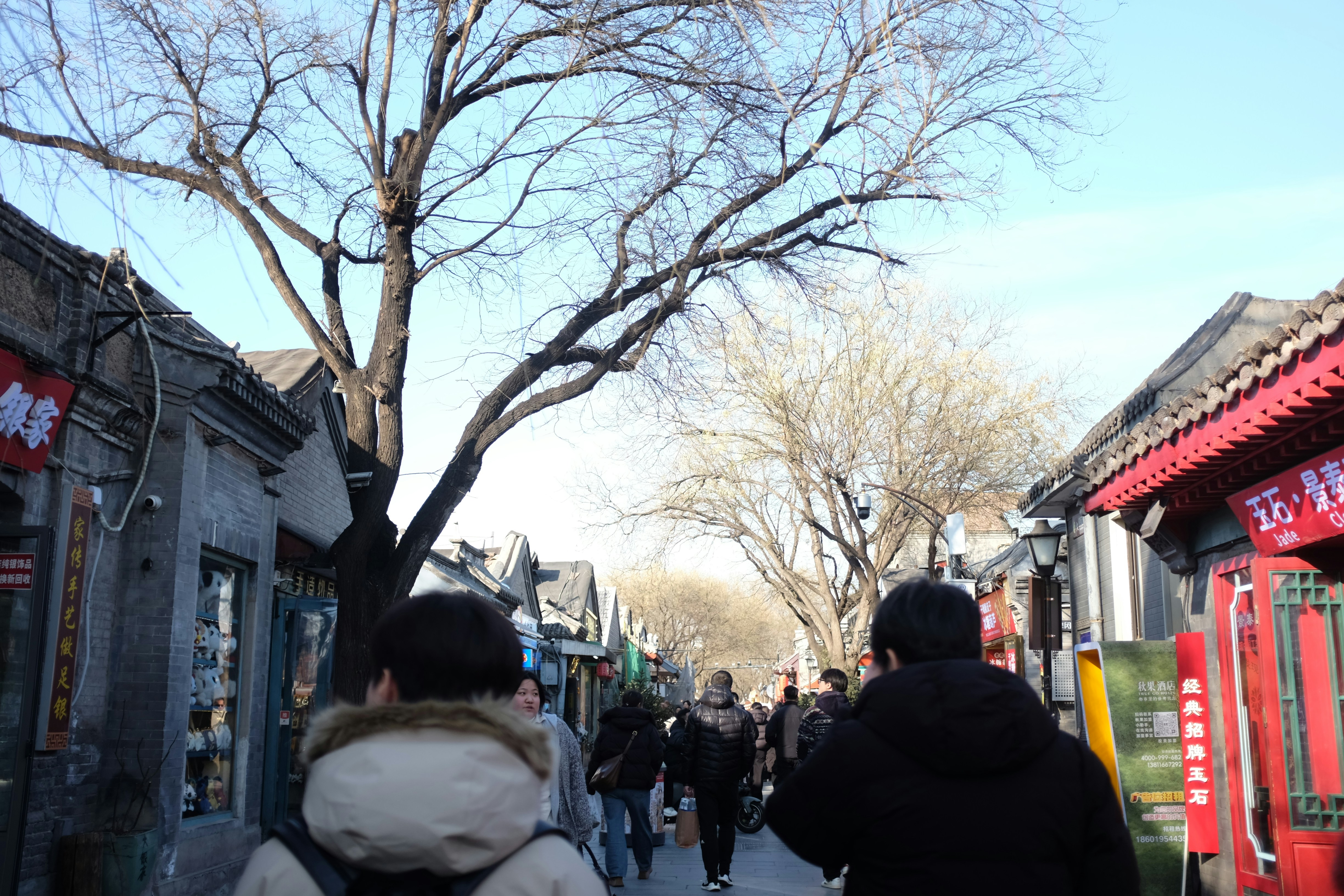 People walking down a narrow street lined with buildings.