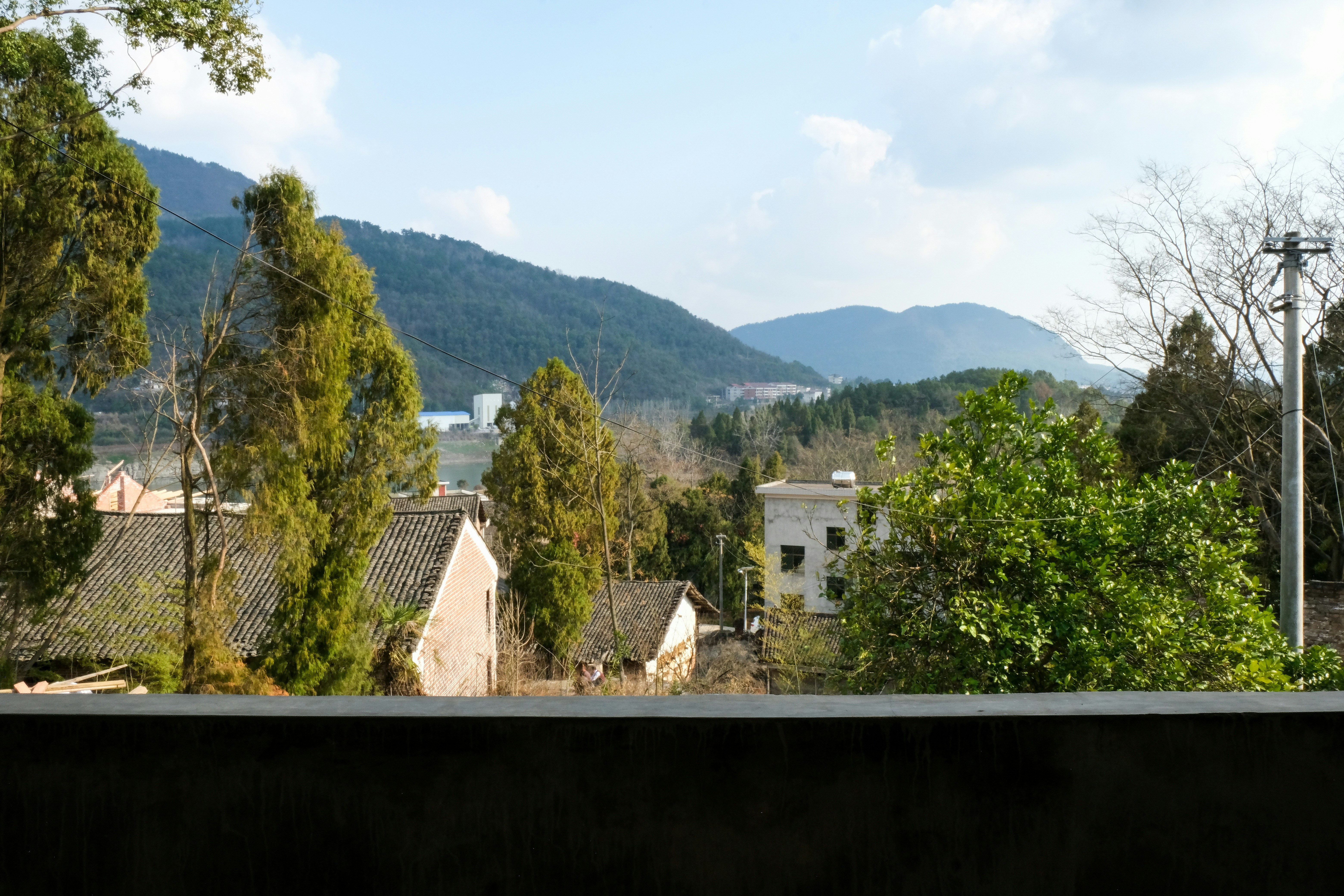 Dorf eingebettet zwischen grünen Bäumen und Bergen