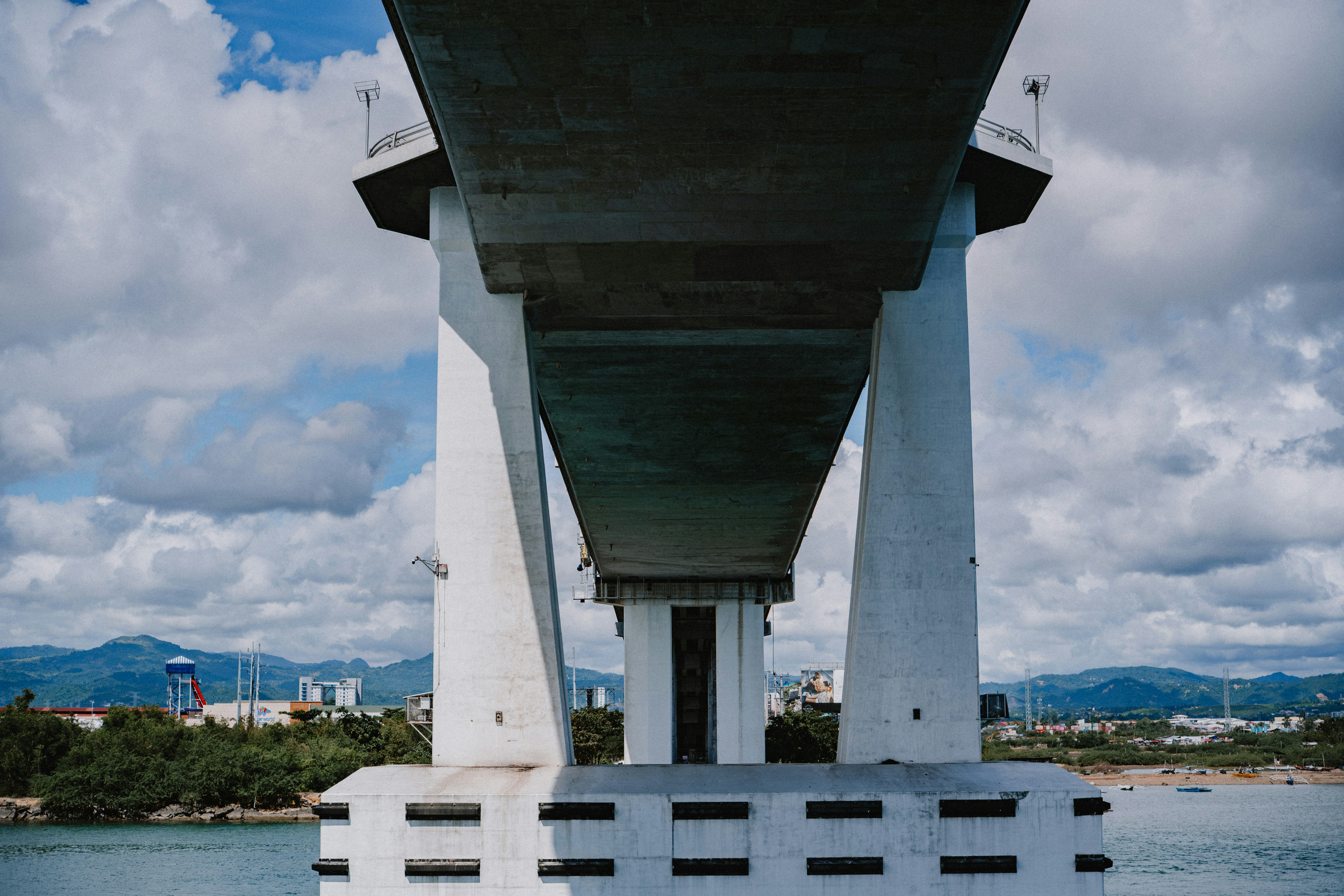 Debajo de un gran puente de hormigón con nubes encima.