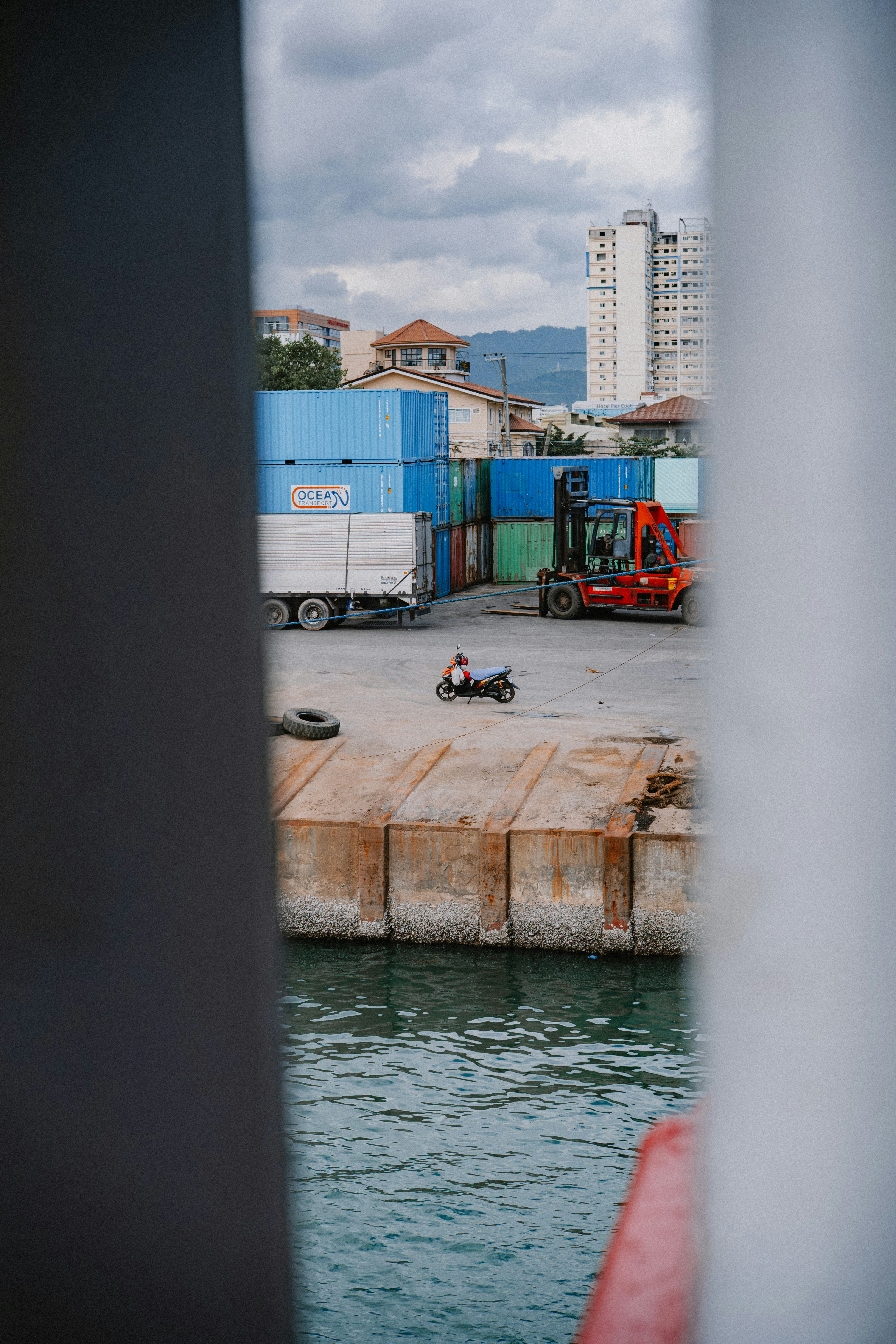 Motorista en un patio de transporte con contenedores y carretilla elevadora