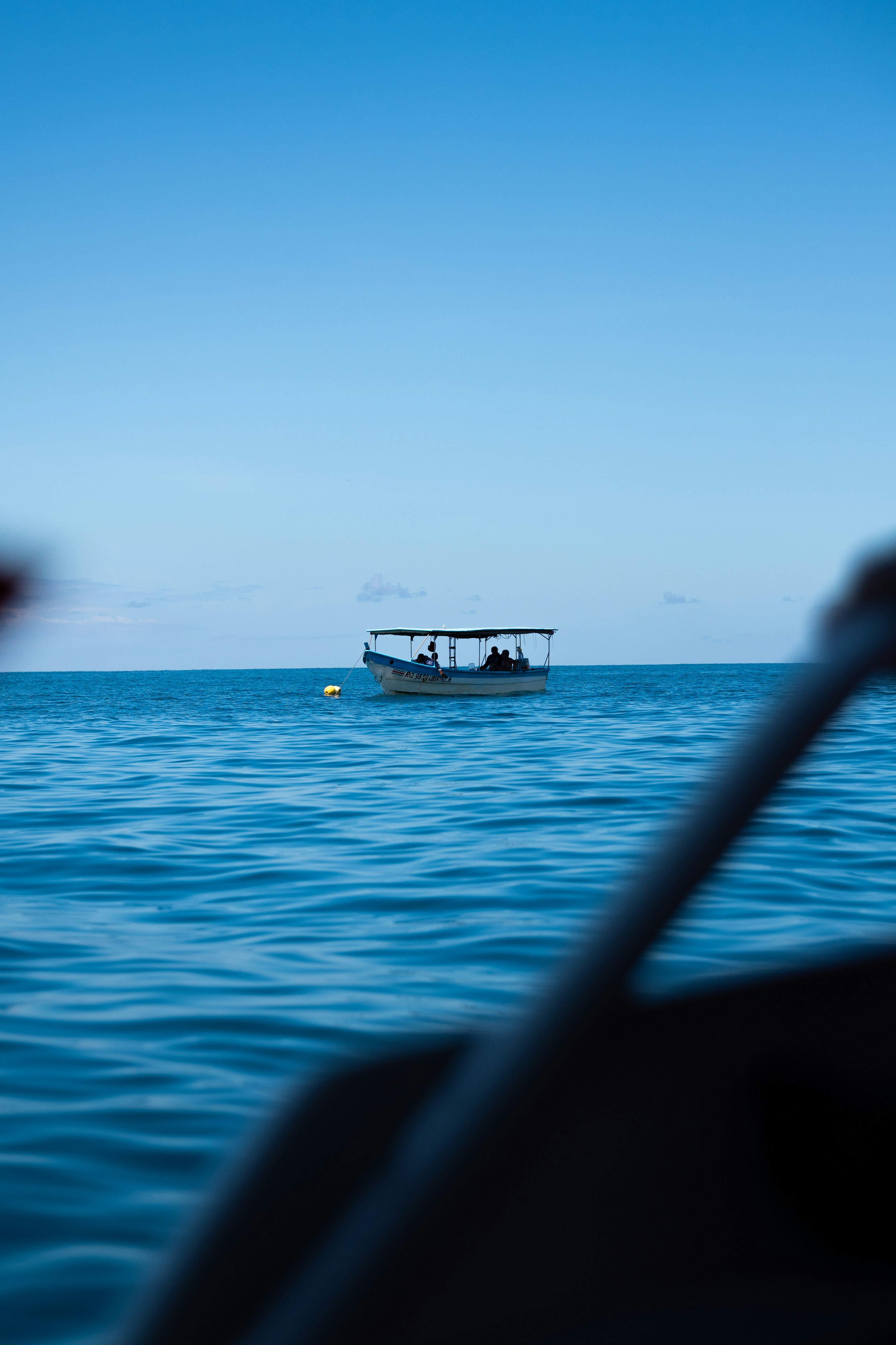 A small boat with people on the calm blue ocean