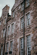 Old stone building with many white windows.