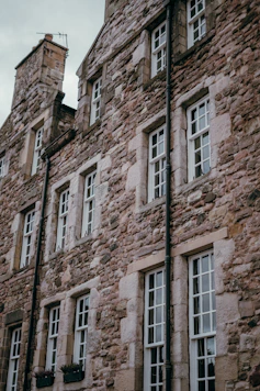 Old stone building with many white windows.
