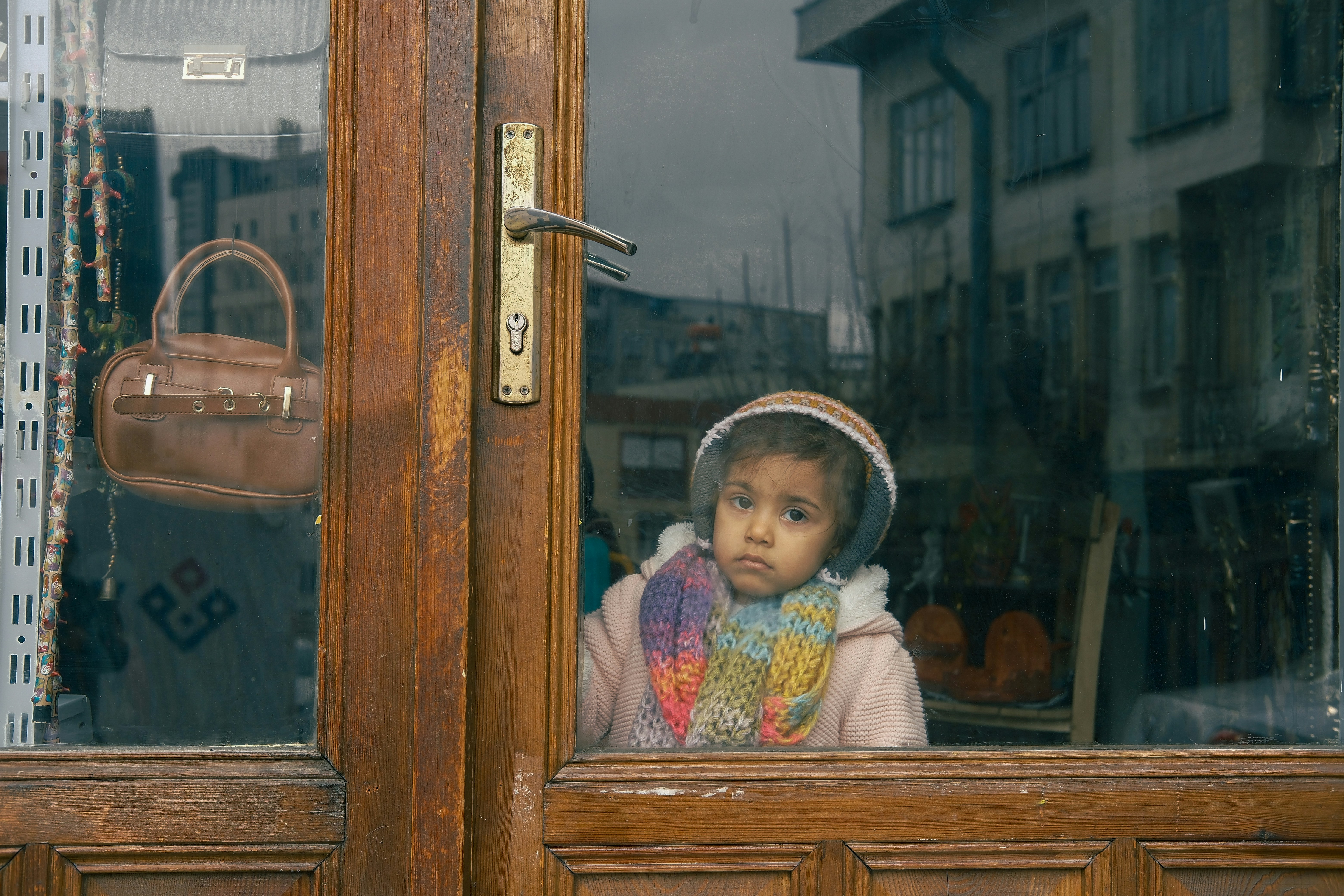 A young child looks out a window thoughtfully.