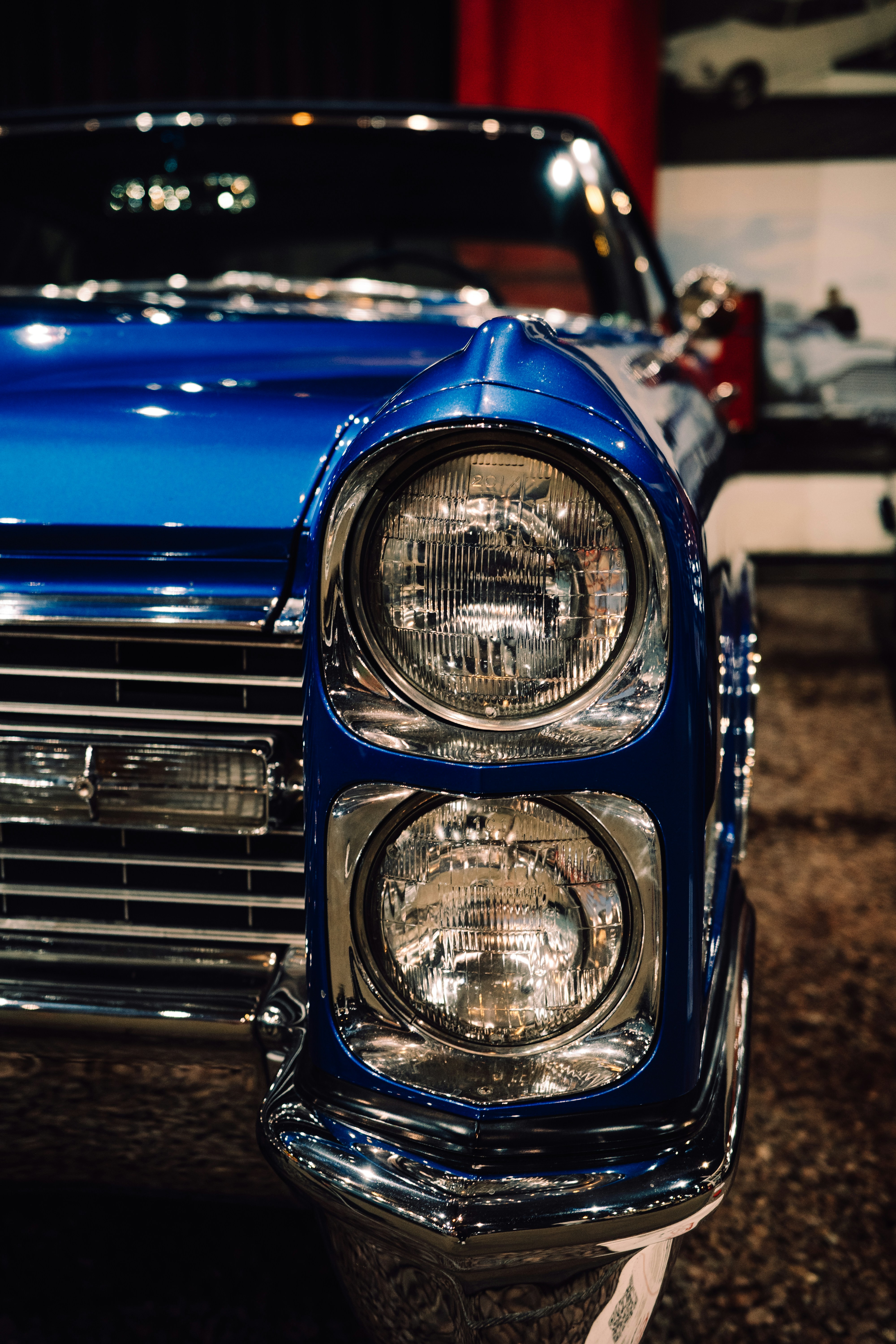 Close-up of a vintage blue car's headlights.
