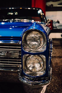 Close-up of a vintage blue car's headlights.