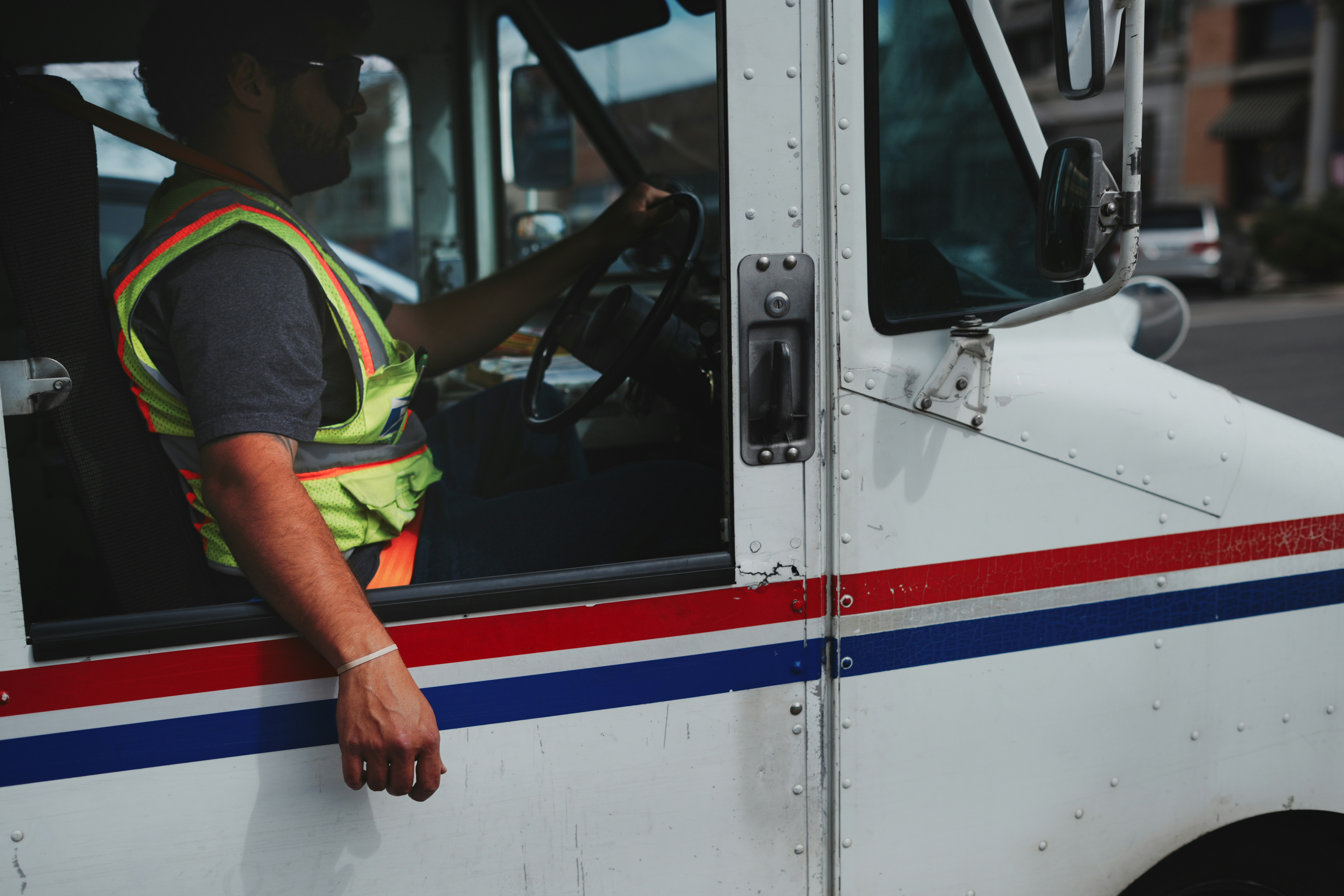Mail carrier driving a white truck