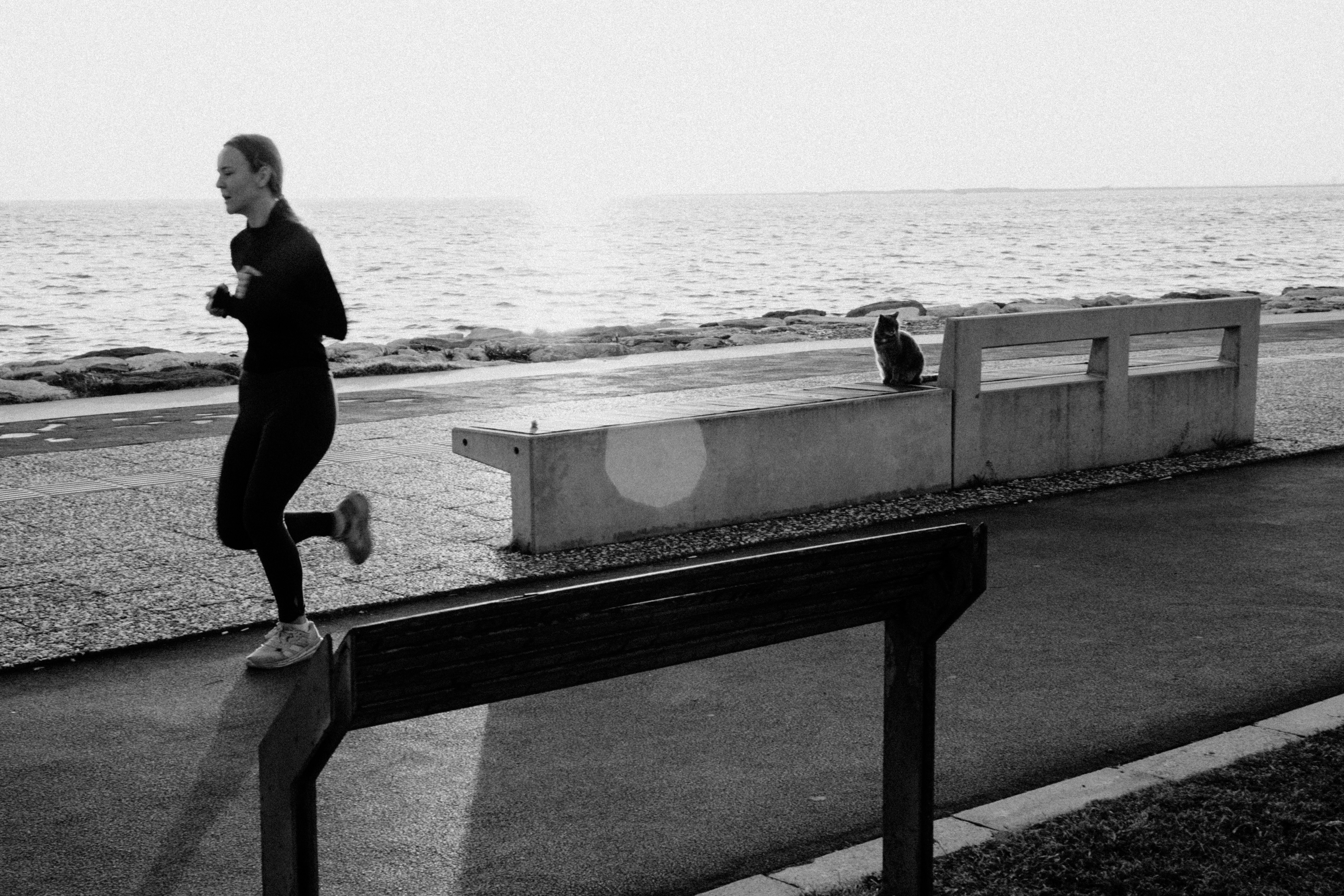 Woman running by the ocean at sunrise