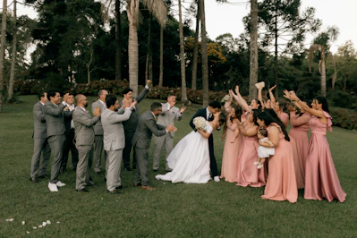 Bride and groom kiss as wedding party cheers