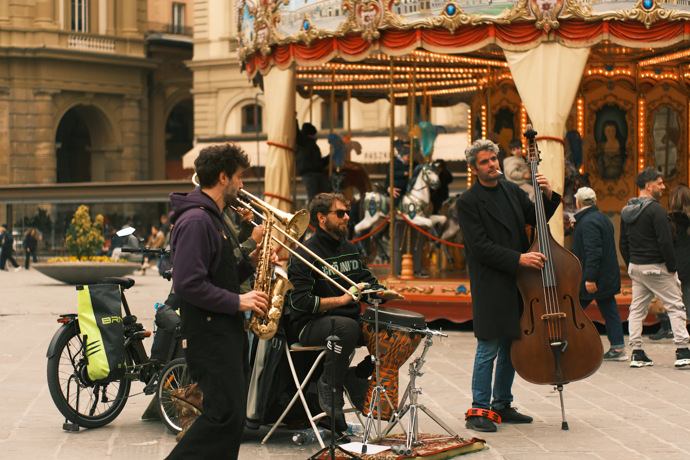 Musiciens qui jouent devant un manège sur une place