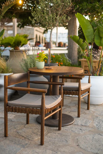 Two chairs and a table on a stone patio.