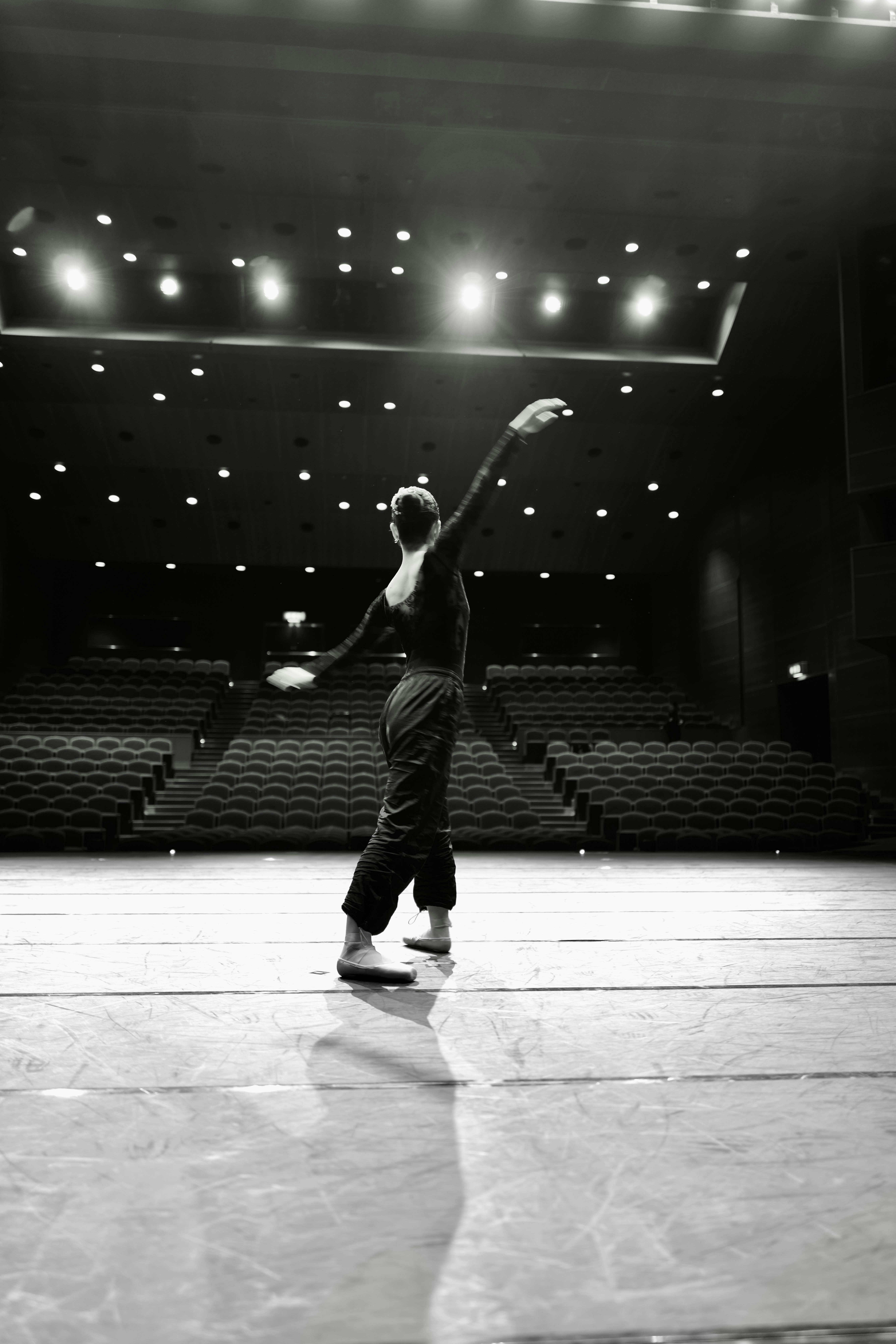 Ballerina dancing on a stage with empty seats