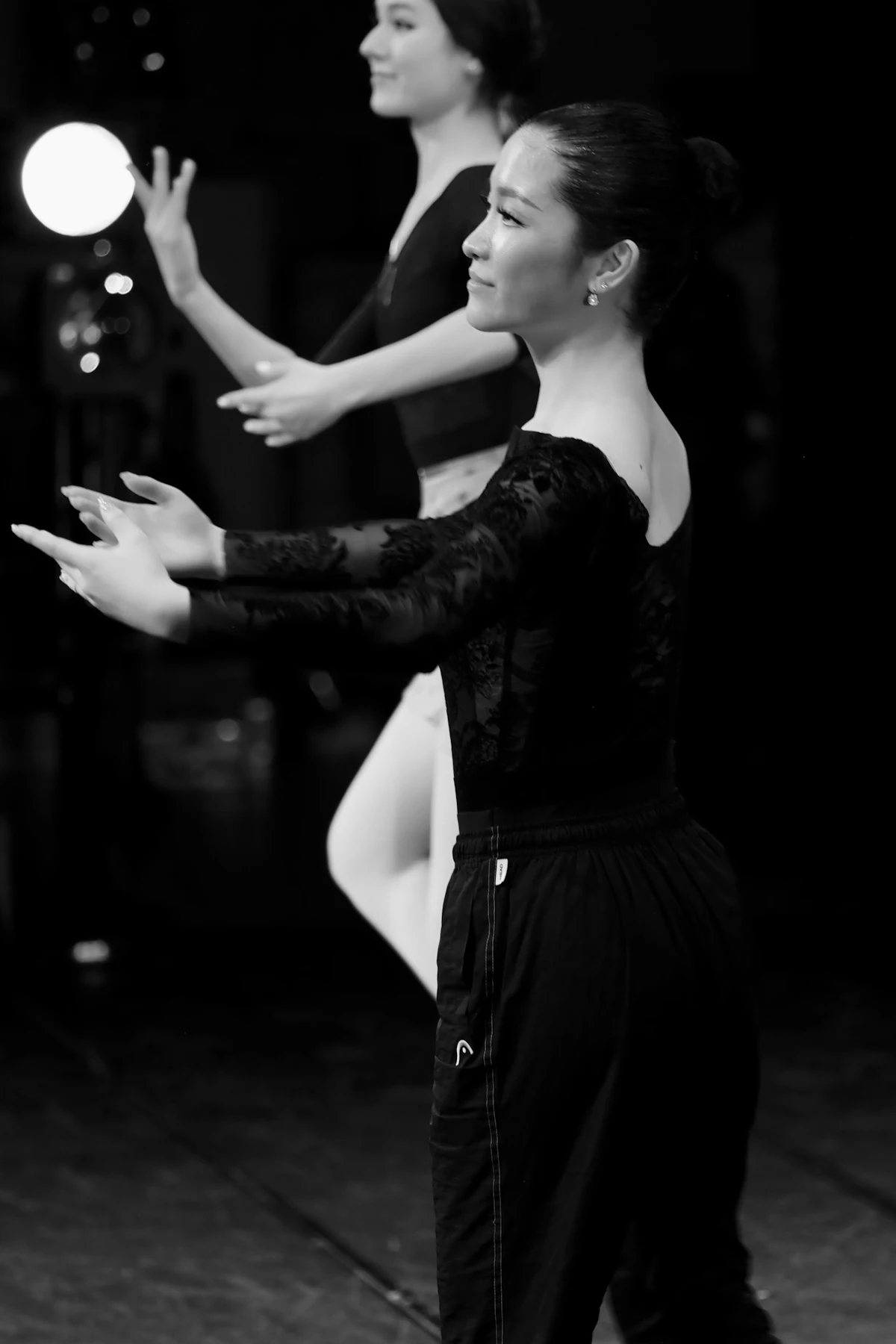 Two dancers in black performing a contemporary duet