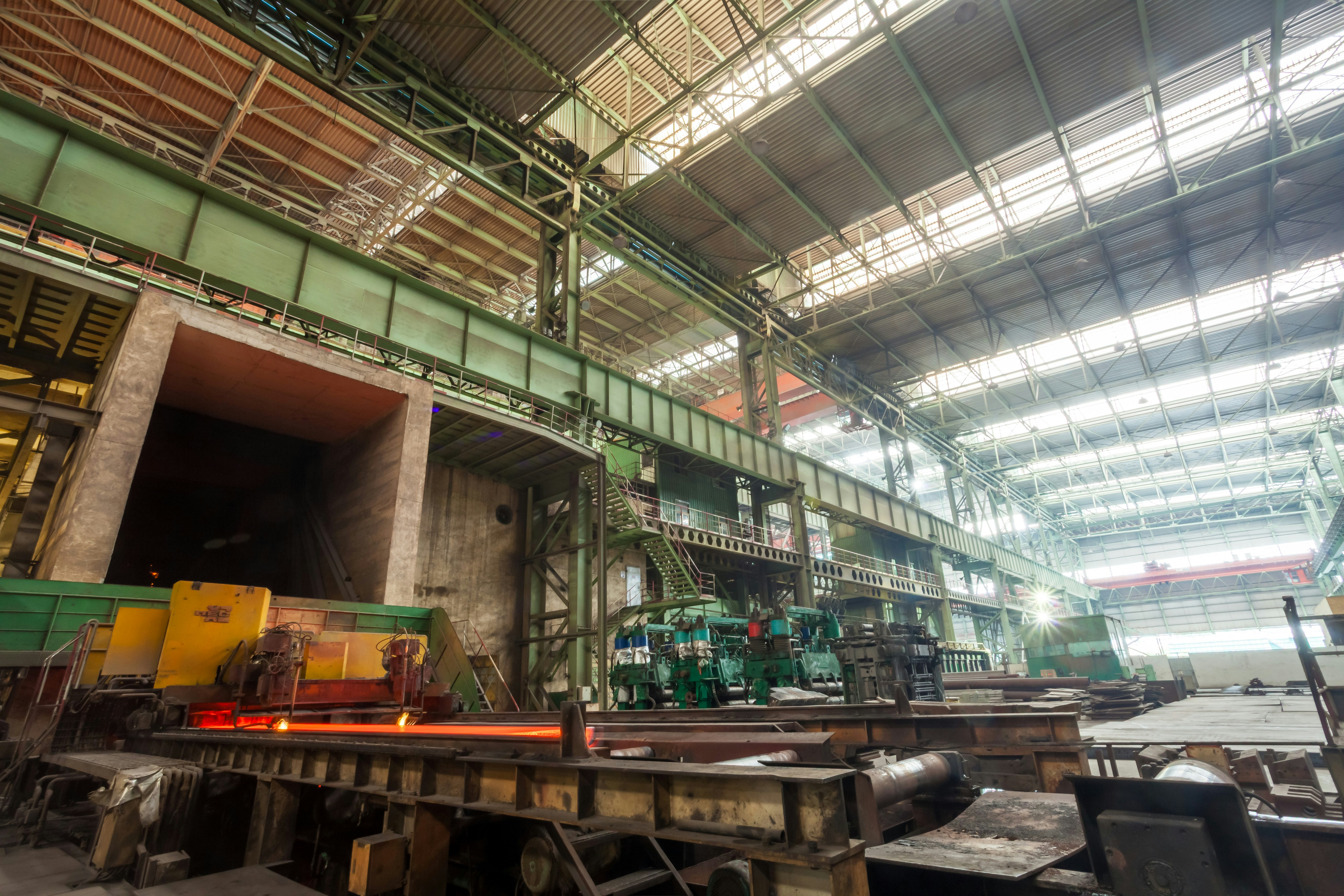 Industrial factory interior with heavy machinery and steel beams.