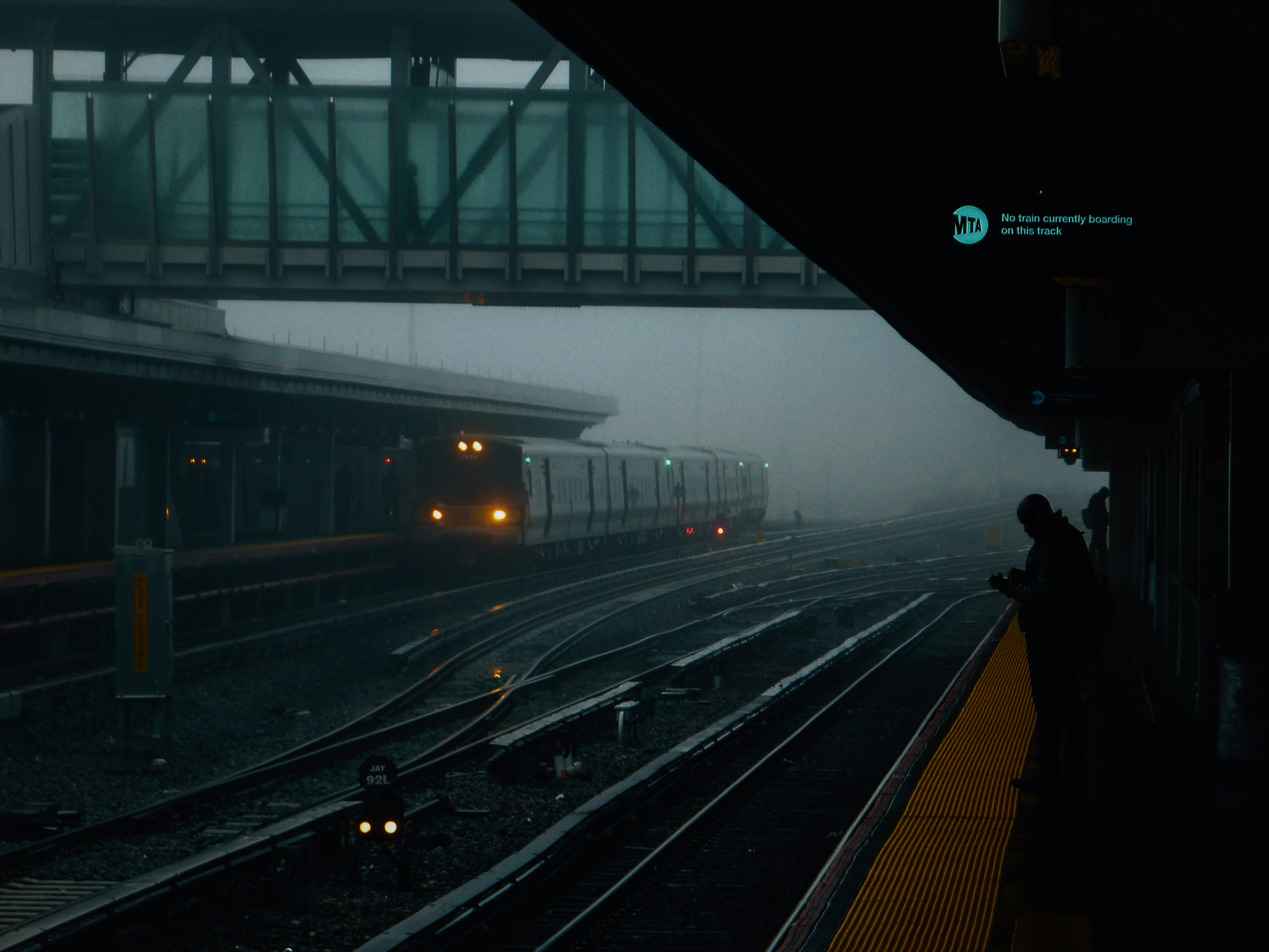 Train arriving at a foggy station platform.