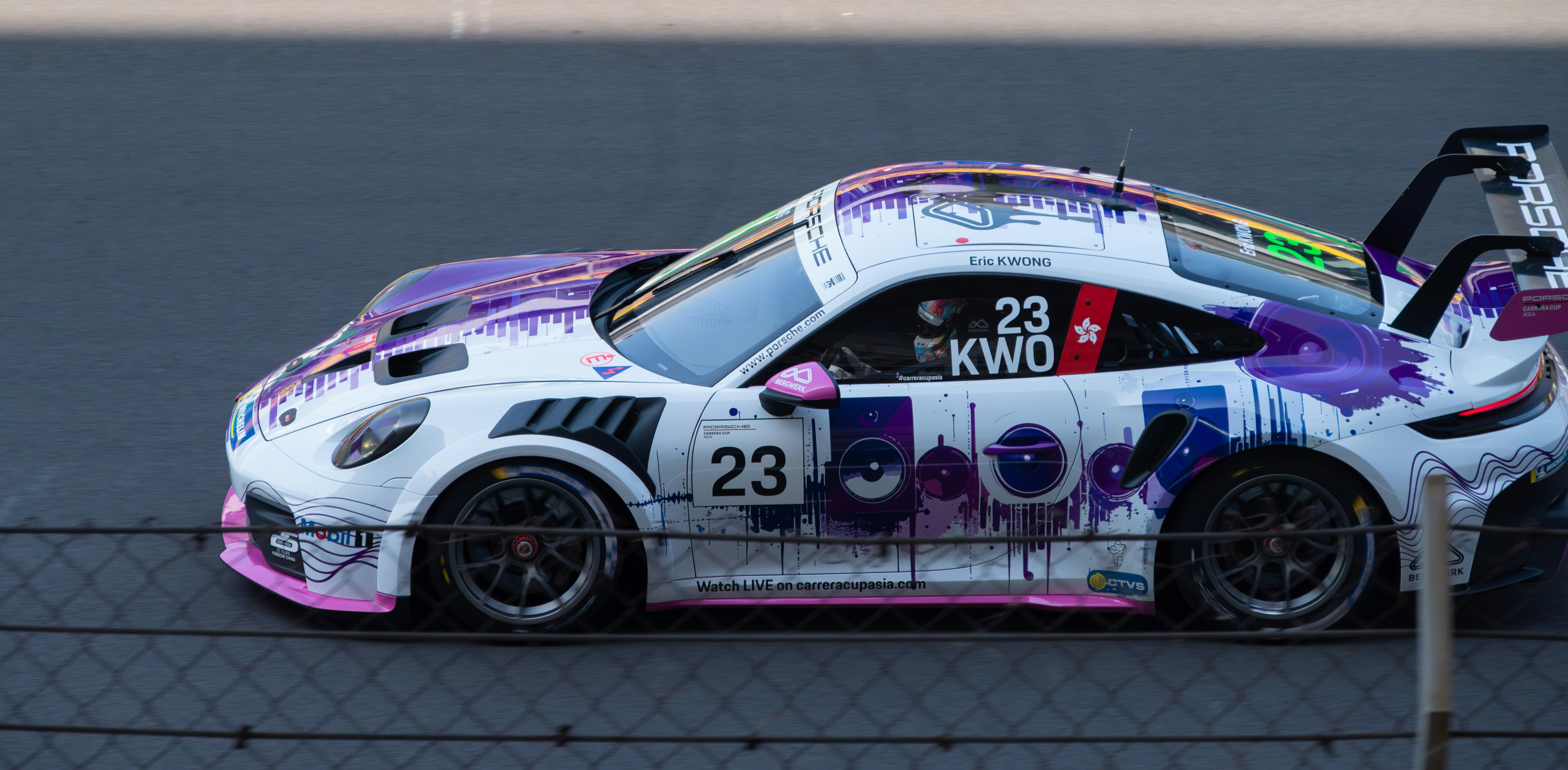 A white race car with purple graphics on track