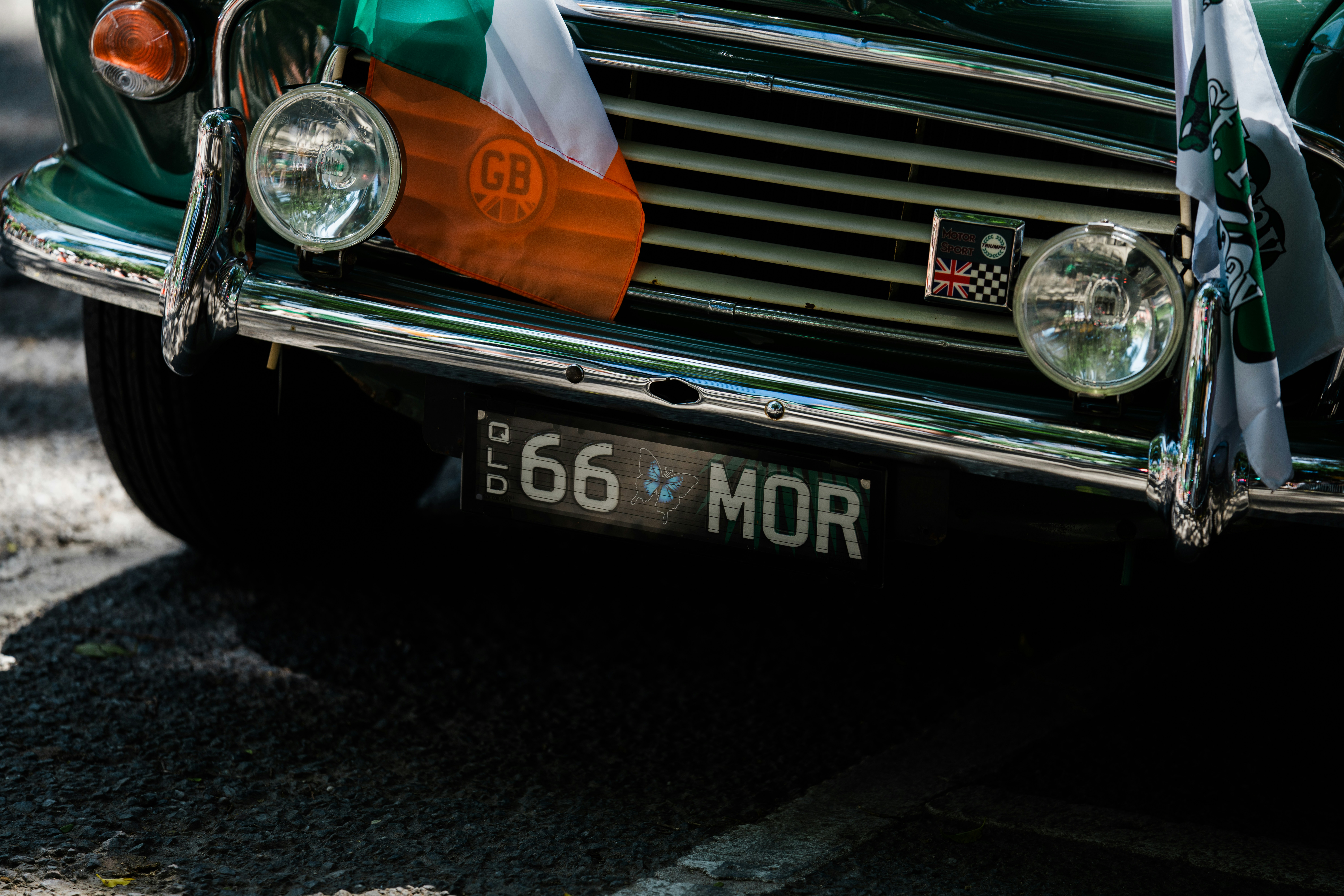 Green vintage car with irish flag on grille