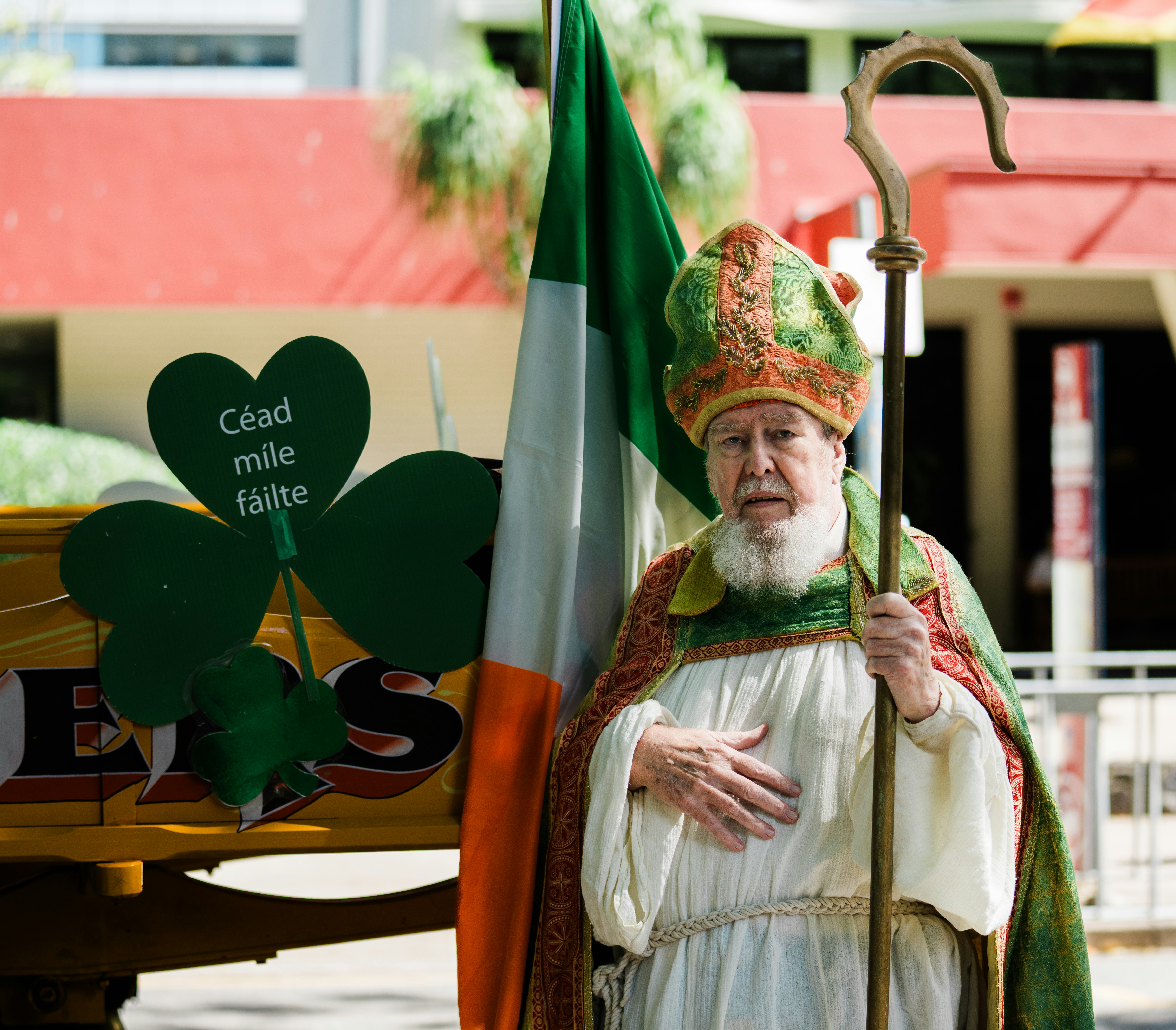 Man in bishop's attire with irish flag and shamrocks