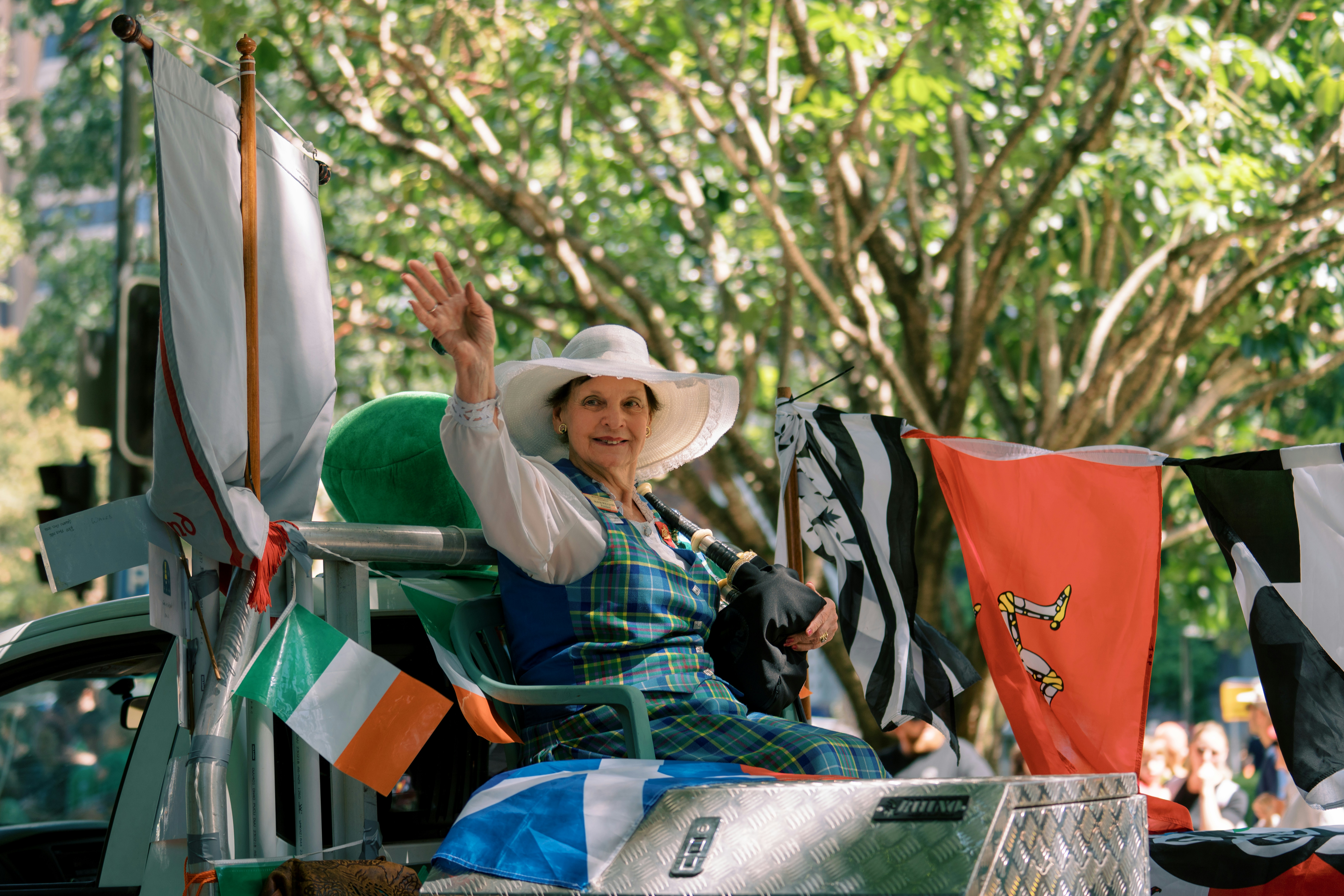 Frau, die von einem Festwagen mit Fahnen winkt