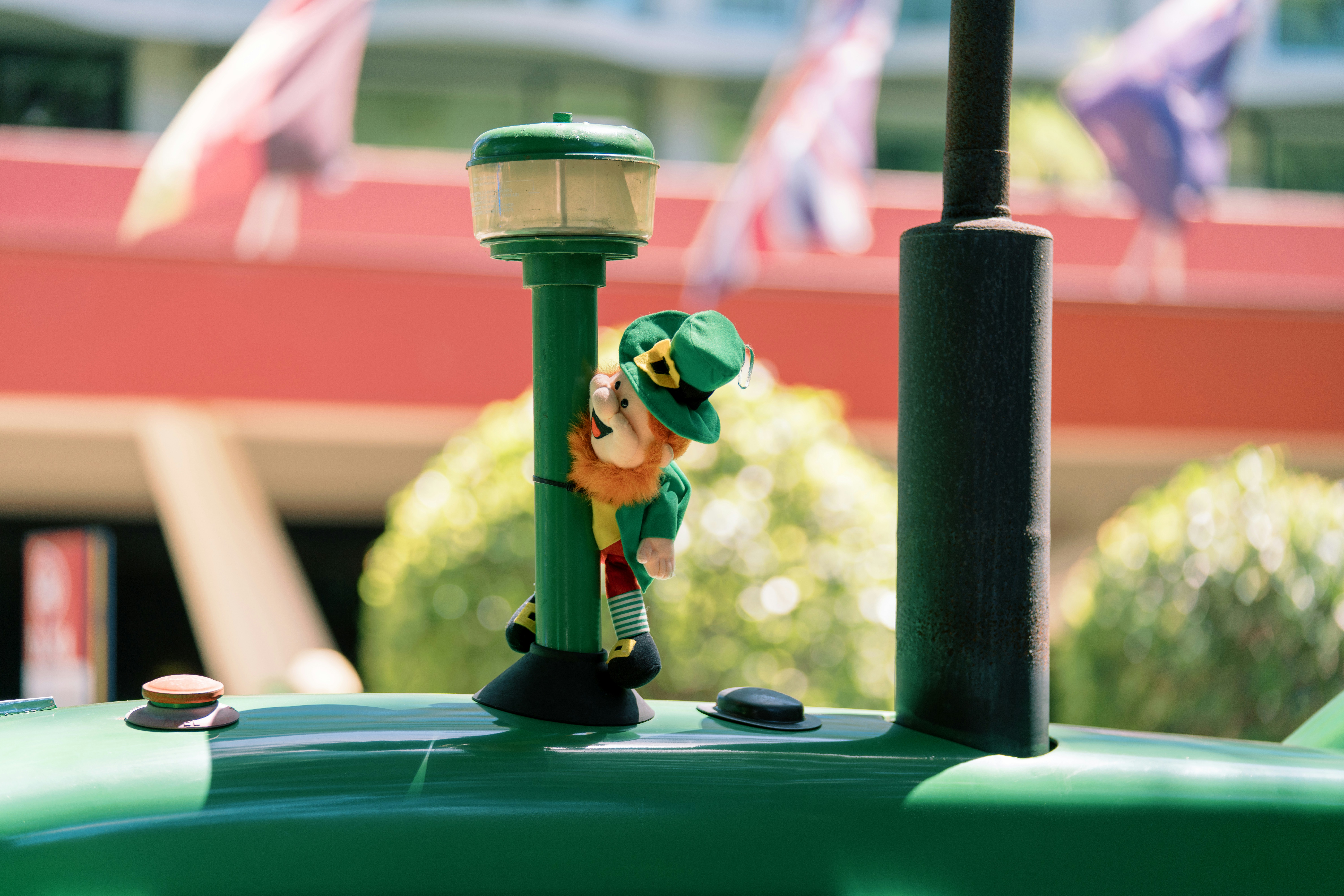 Leprechaun mascot peeking around a green pole