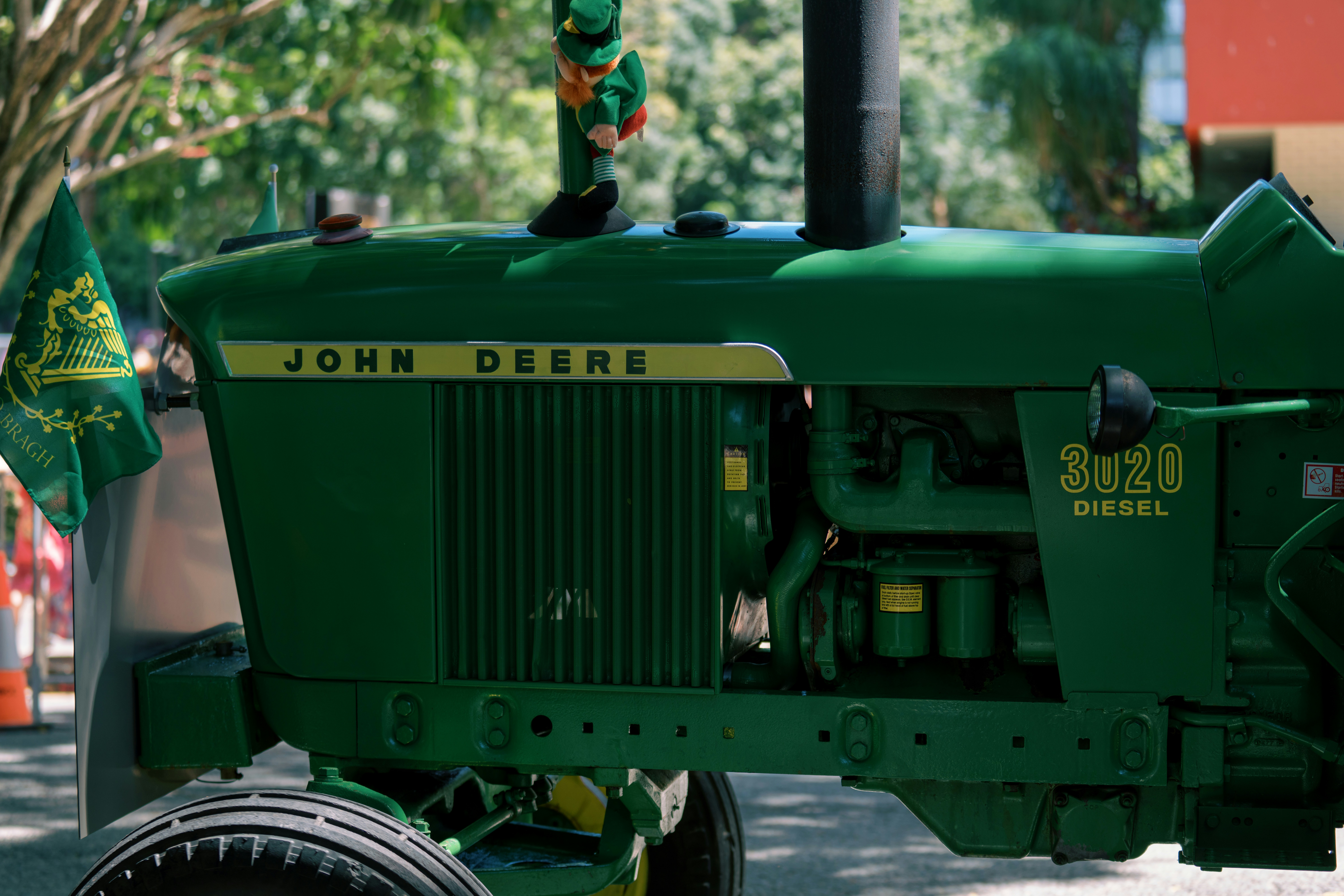 Green john deere tractor with a figure on top