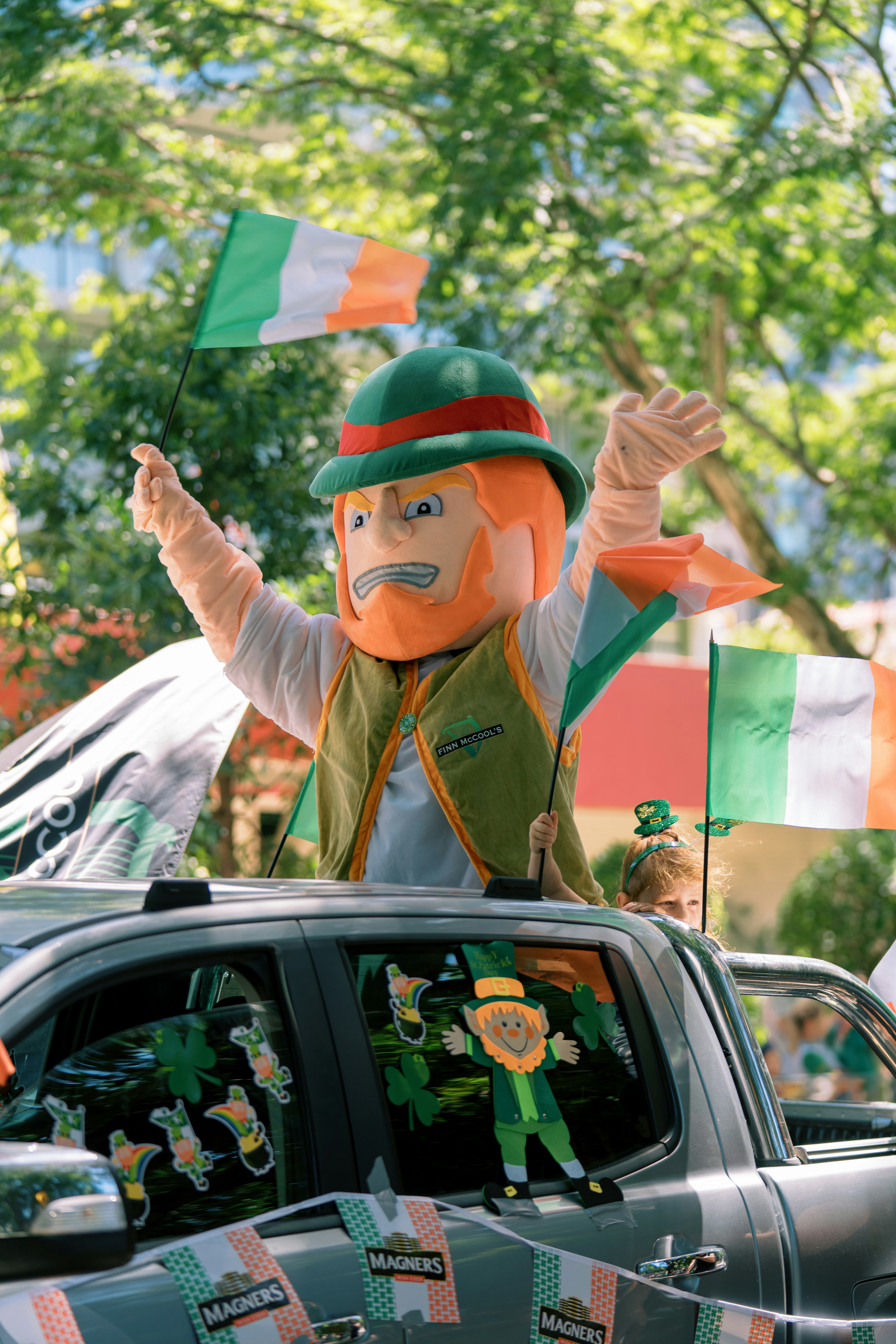 Leprechaun-Maskottchen schwenkt Fahnen während einer Parade