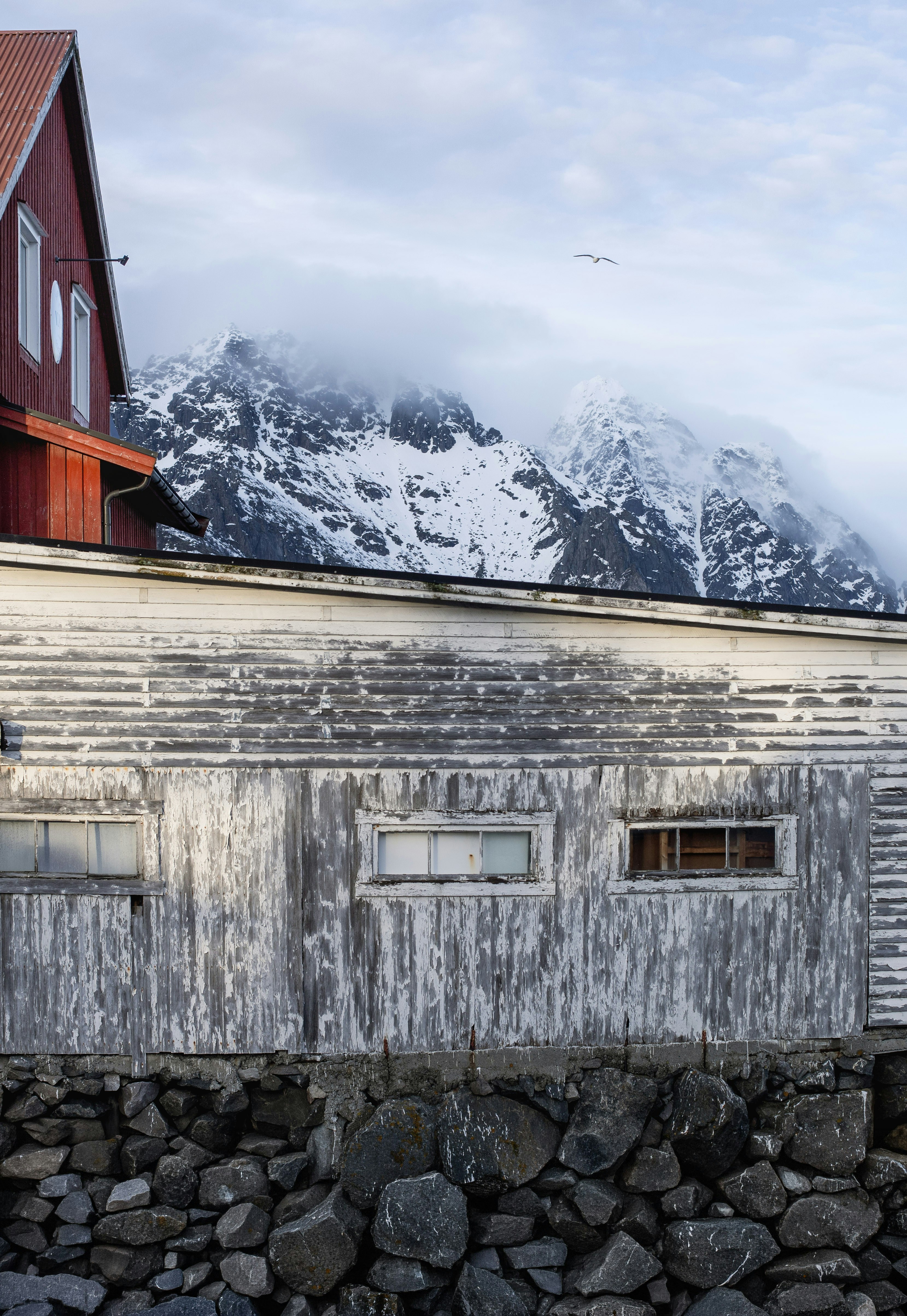 Edificio desgastado con montañas nevadas detrás