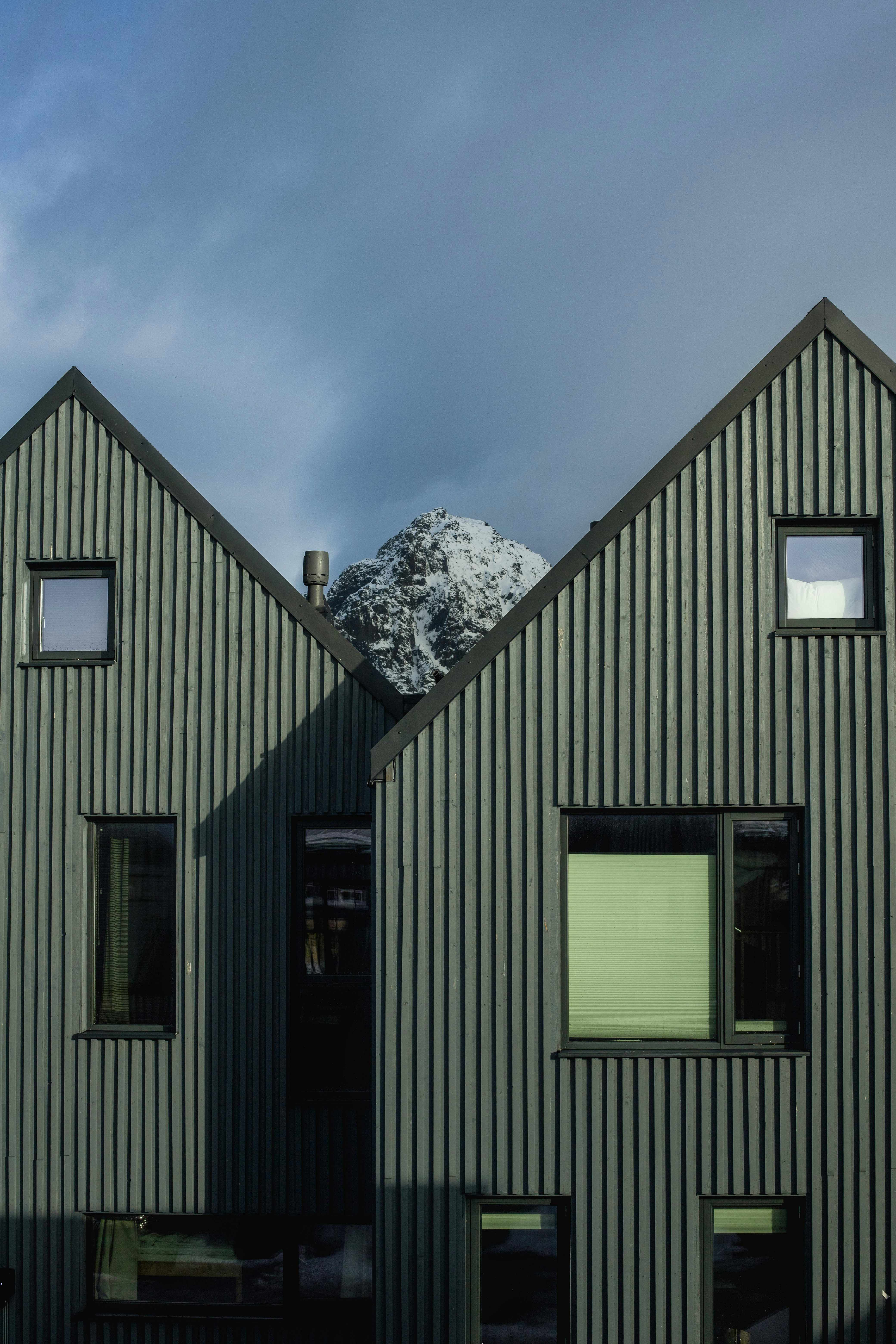 Casas modernas con revestimiento de chapa ondulada y fondo de montaña