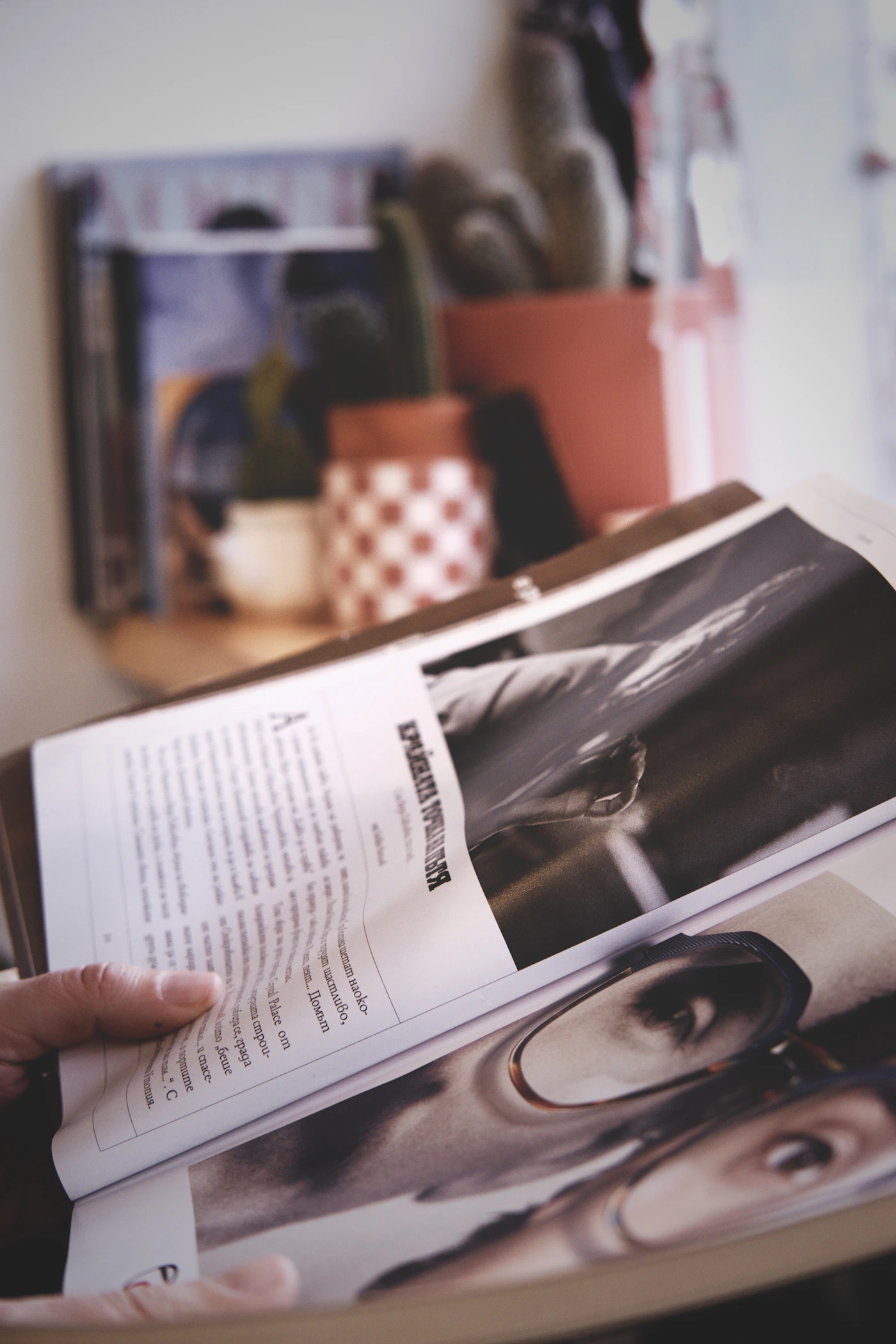 Person reading an open magazine with black-and-white photography