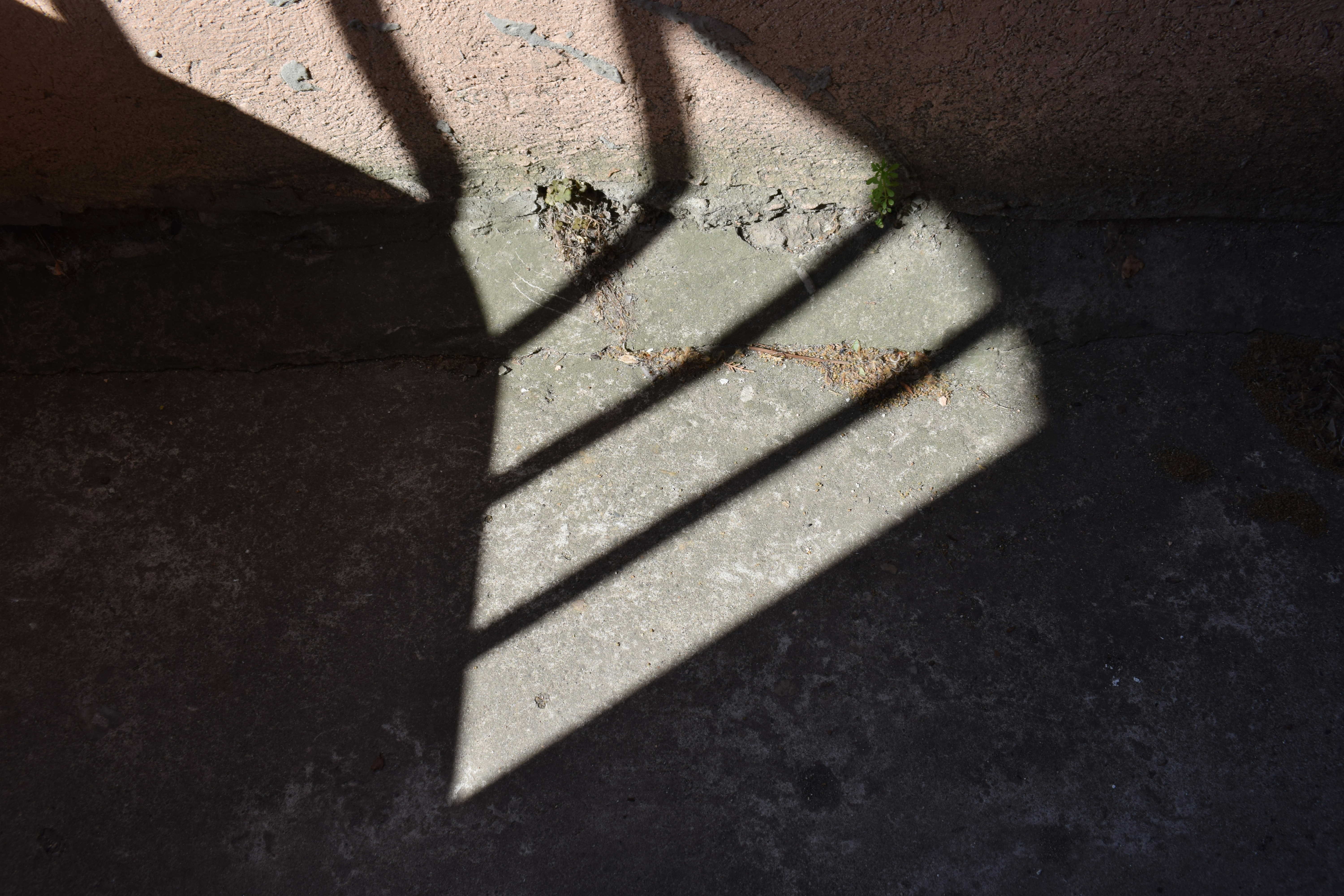 Striped shadows cast on a concrete surface.