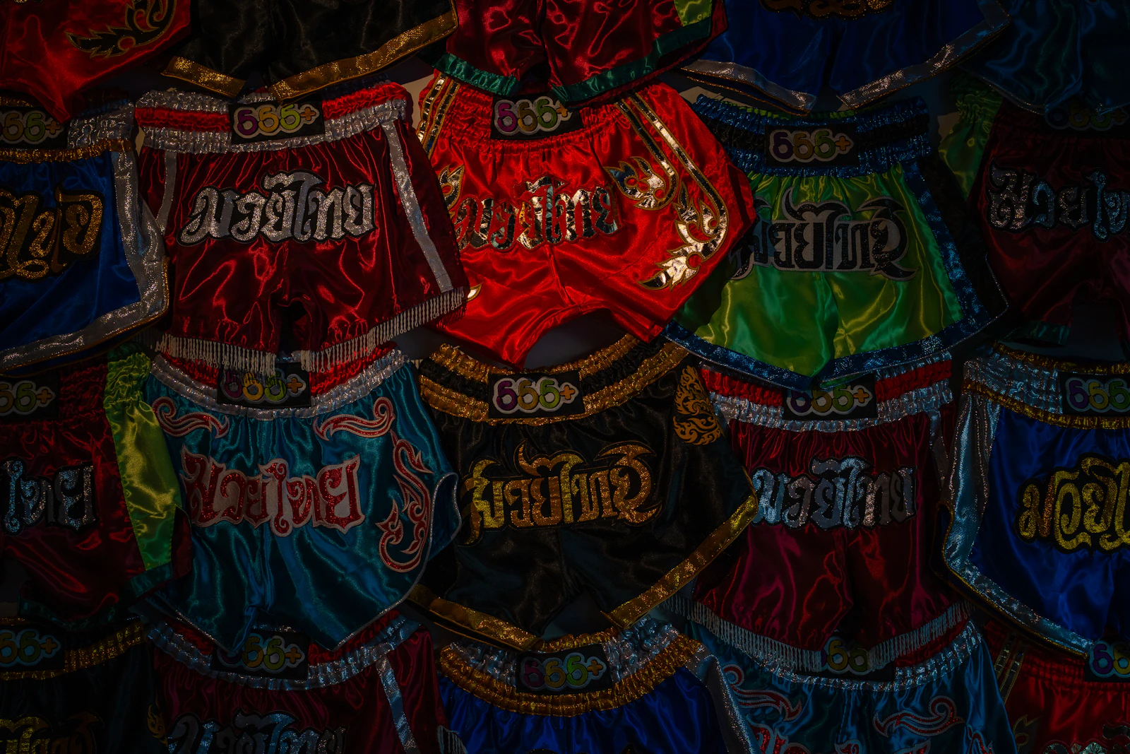 A display wall of colourful traditional Muay Thai shorts