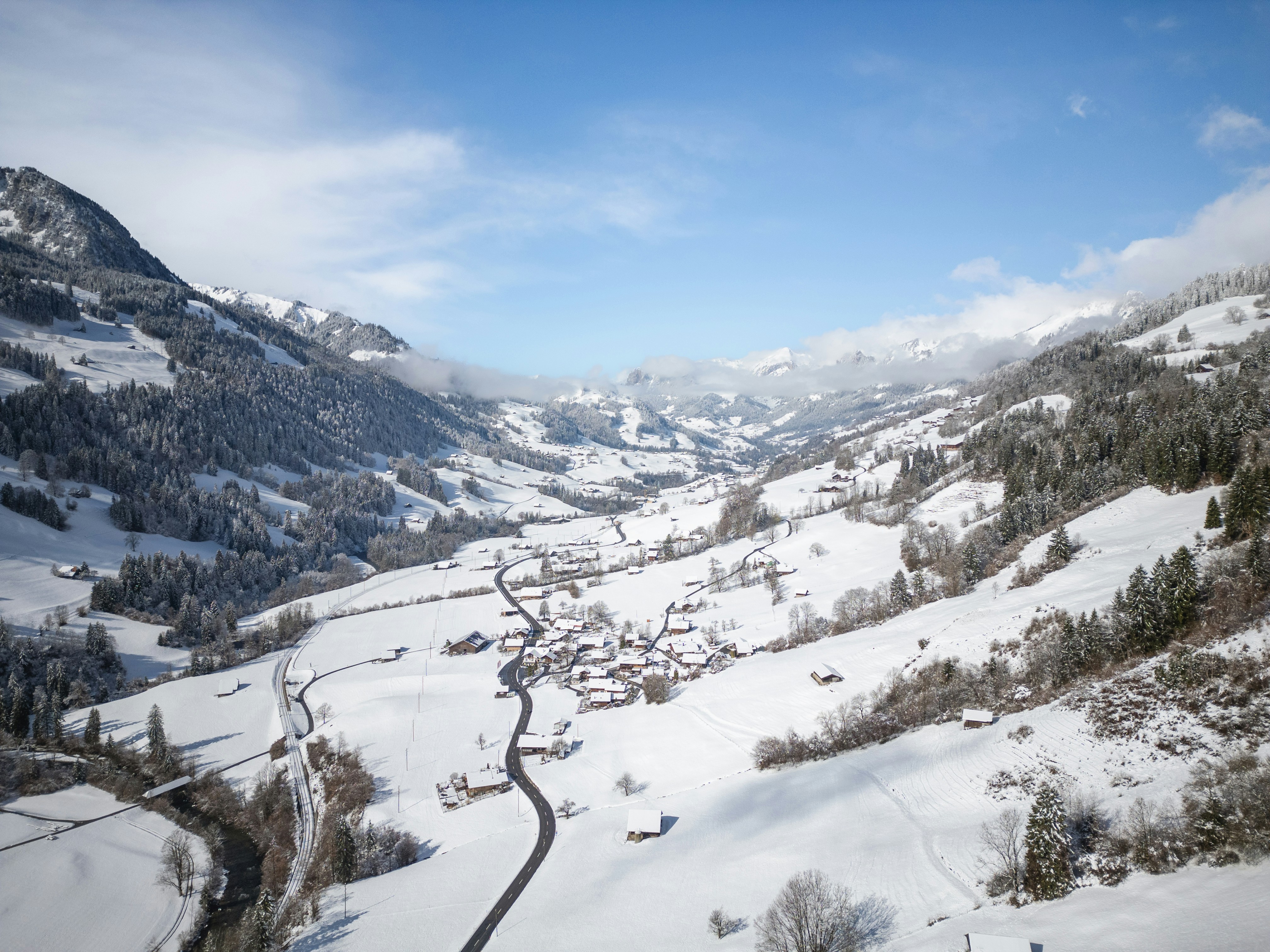 Snowy valley with a village and winding road