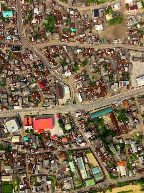 Vue aérienne d’un quartier urbain dense, avec ses toits, ses parcelles et une grande avenue