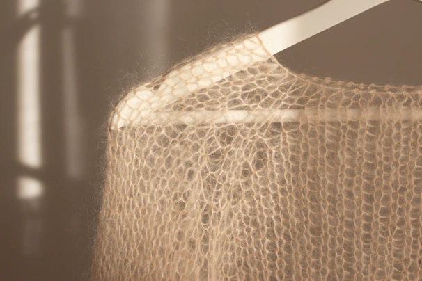 Delicate knit sweater hanging on a white hanger