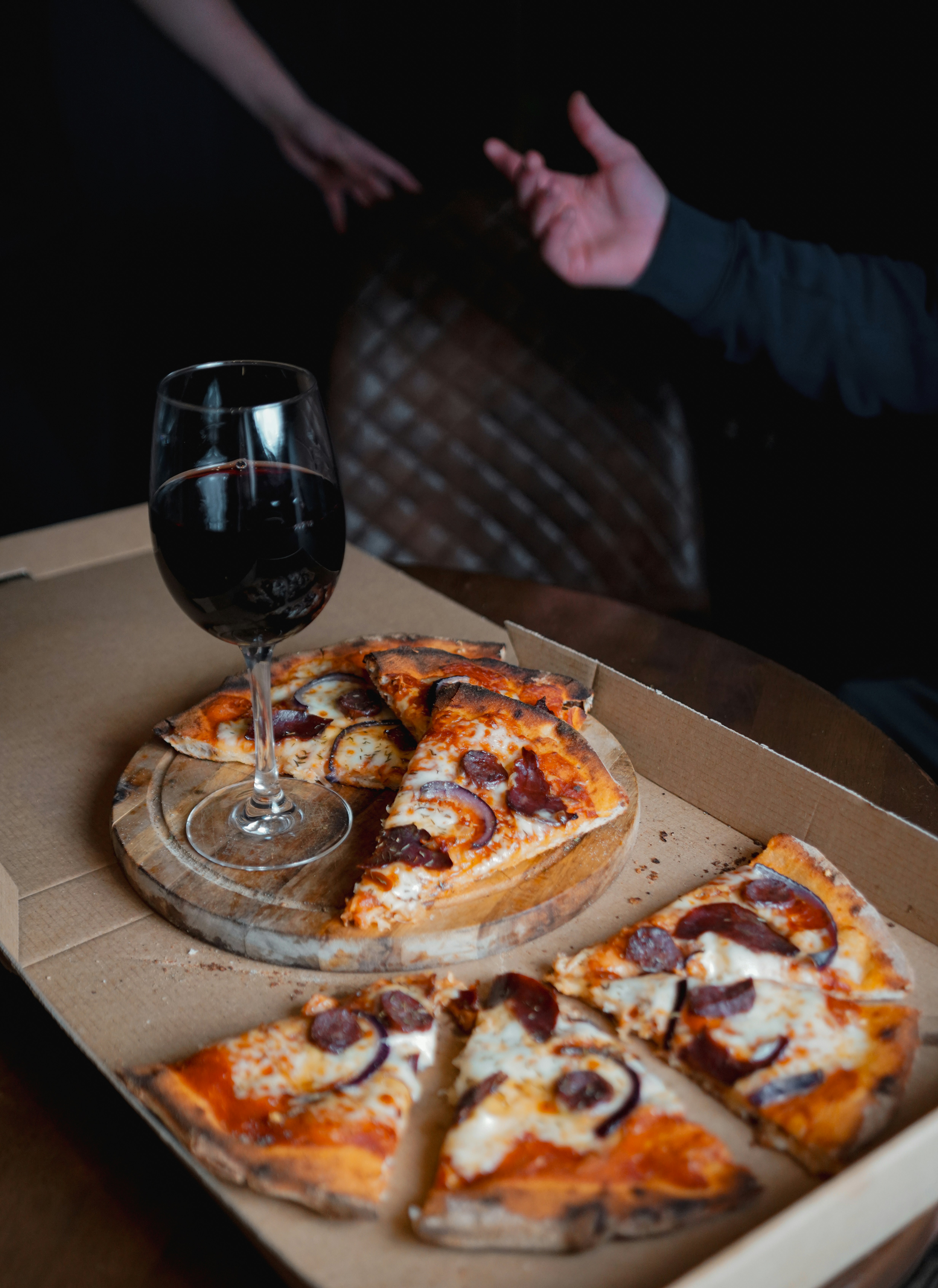 Slices of pizza and a glass of red wine