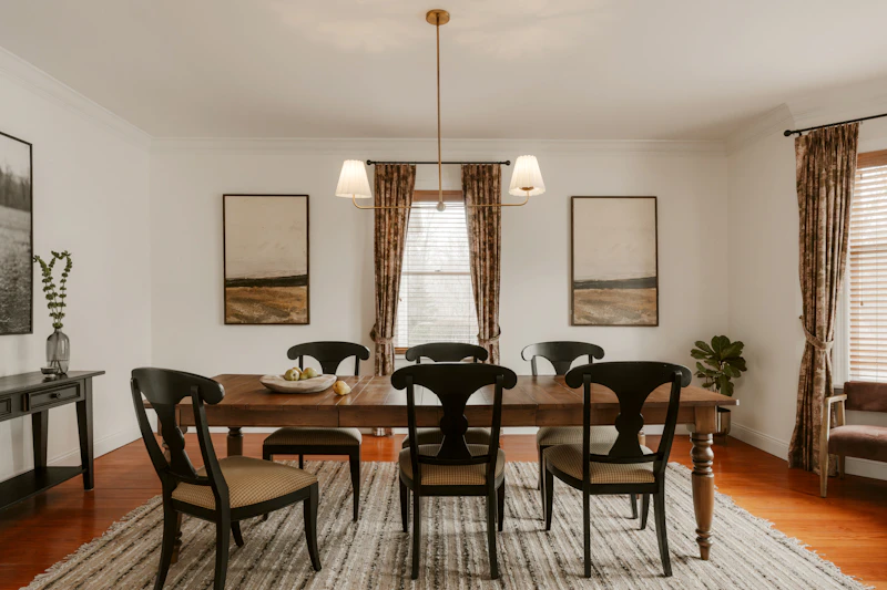 A formal dining room with a long wooden table and chairs
