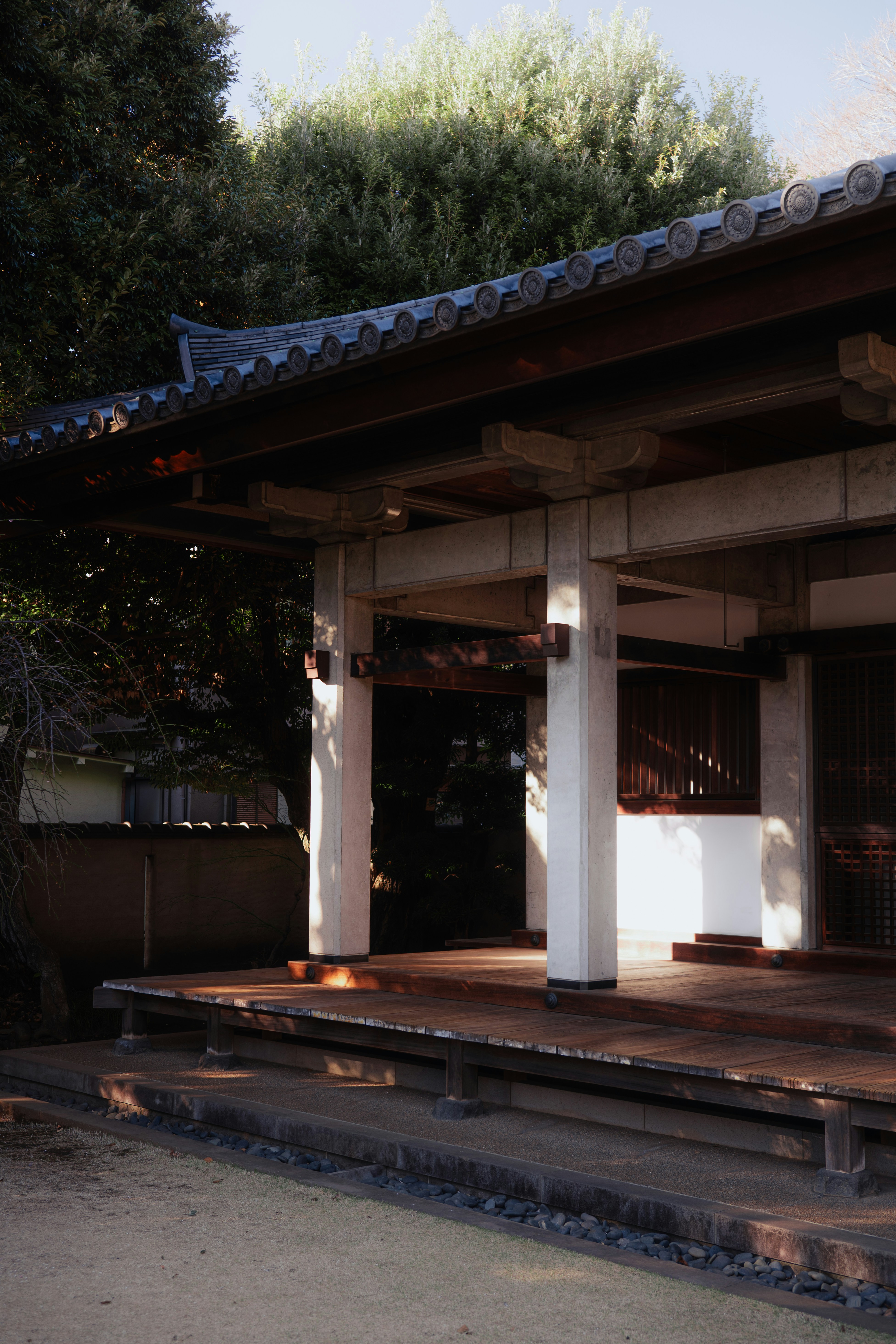 Traditional japanese building with tiled roof and wooden porch.