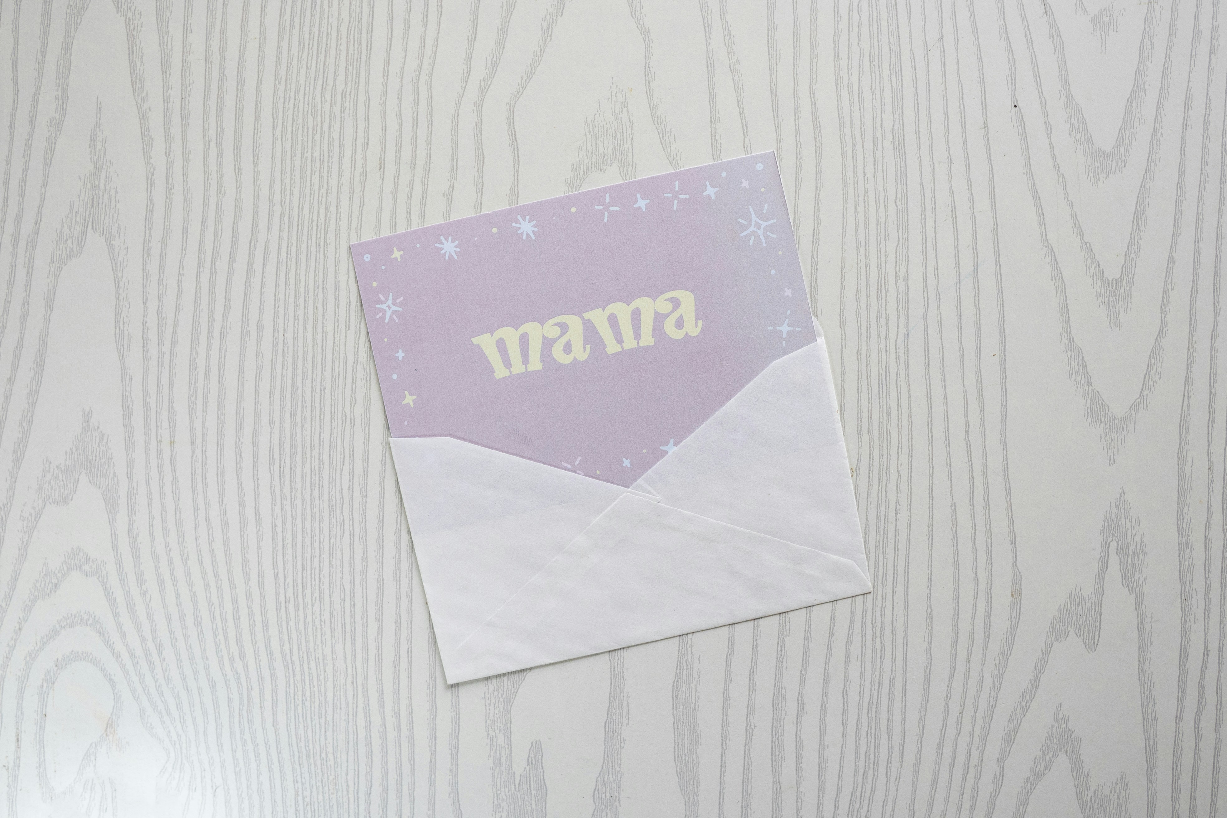 Eine hellviolette Karte mit "Mama" darauf.