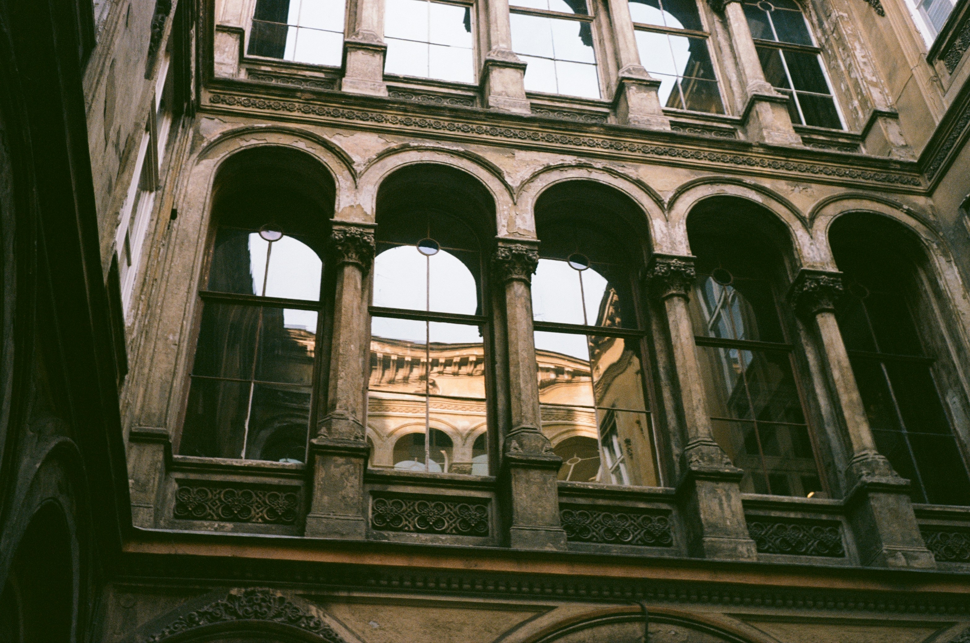 Arched windows reflect buildings in a courtyard