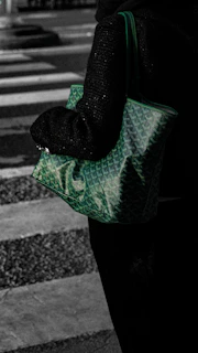 A person carries a green patterned tote bag