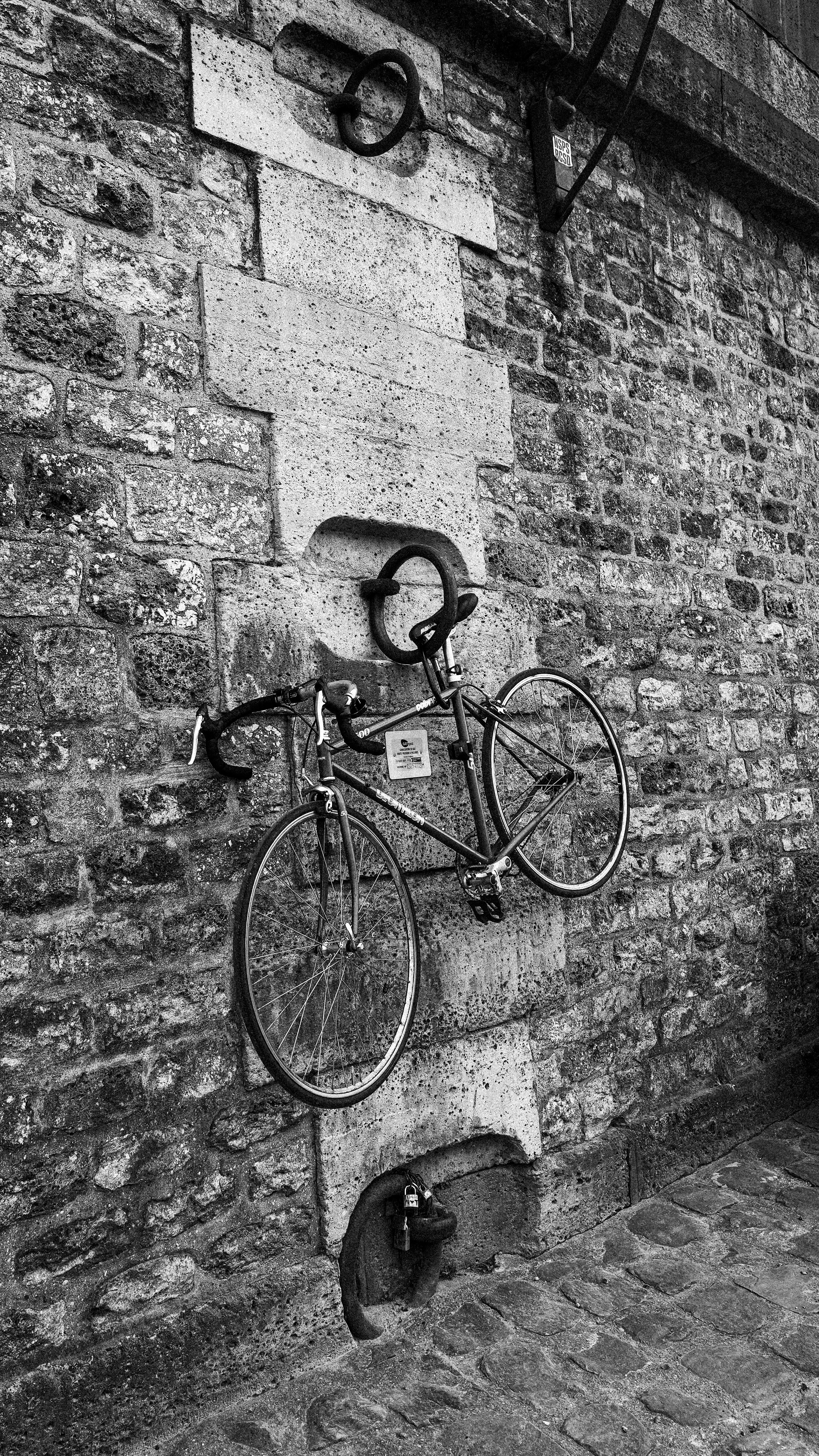 A vintage bicycle mounted on a stone wall.