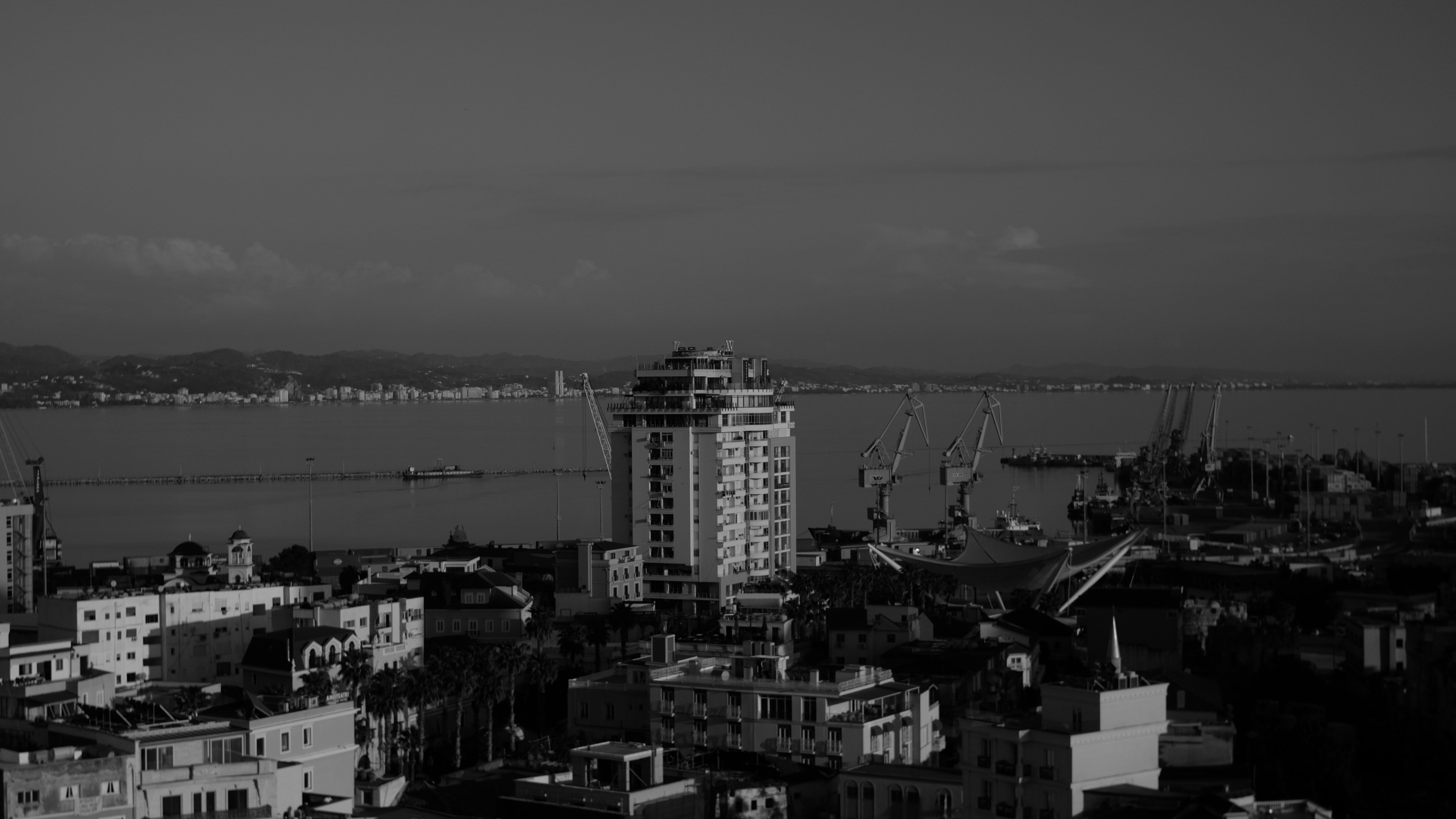 Paesaggio urbano con edifici alti e gru portuali