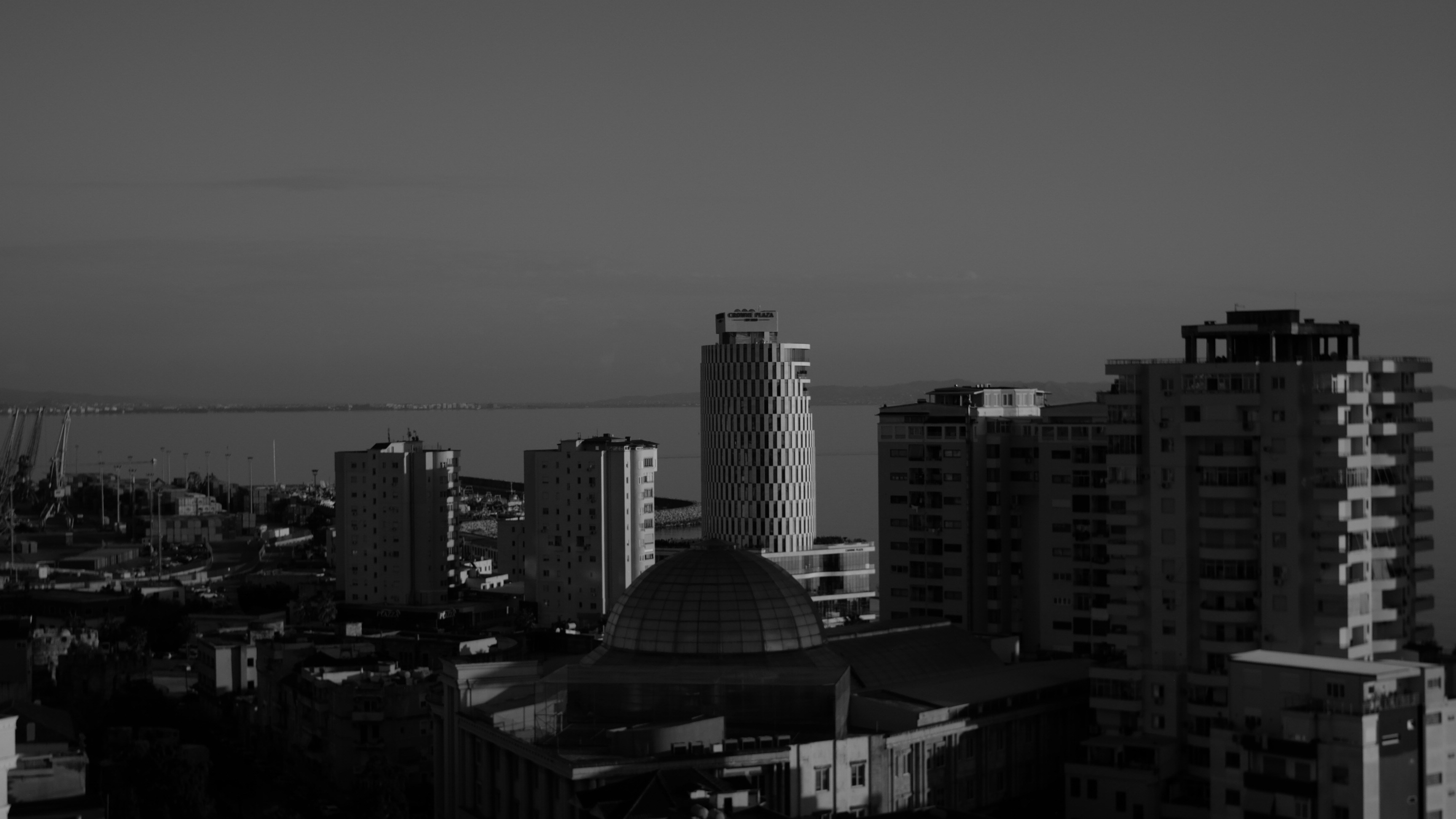 Skyline della città con edifici moderni e una struttura a cupola.