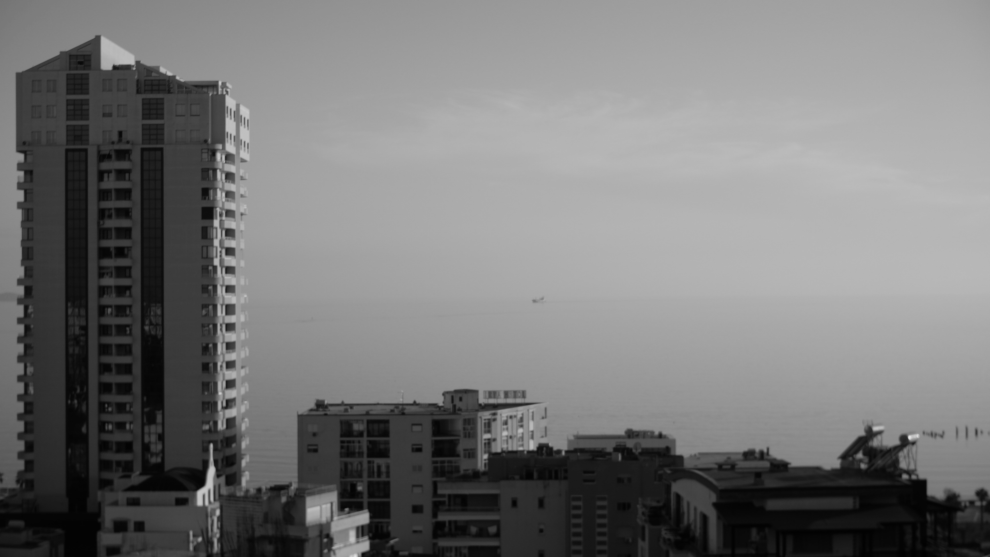 Edificio alto che domina lo skyline della città e l'aereo.